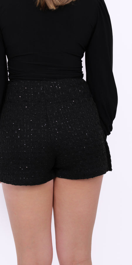 Deze zwarte broek rok combineert het elegante silhouet van een rok met het comfort van een broekje. De subtiele pailletten zorgen voor een speelse sparkle zonder dat het design te opvallend wordt. Dankzij de flatterende pasvorm is dit item perfect voor zowel casual chic als een avondje uit. Style deze skort met een satijnen blouse en laarsjes voor een effortless stijlvolle look.