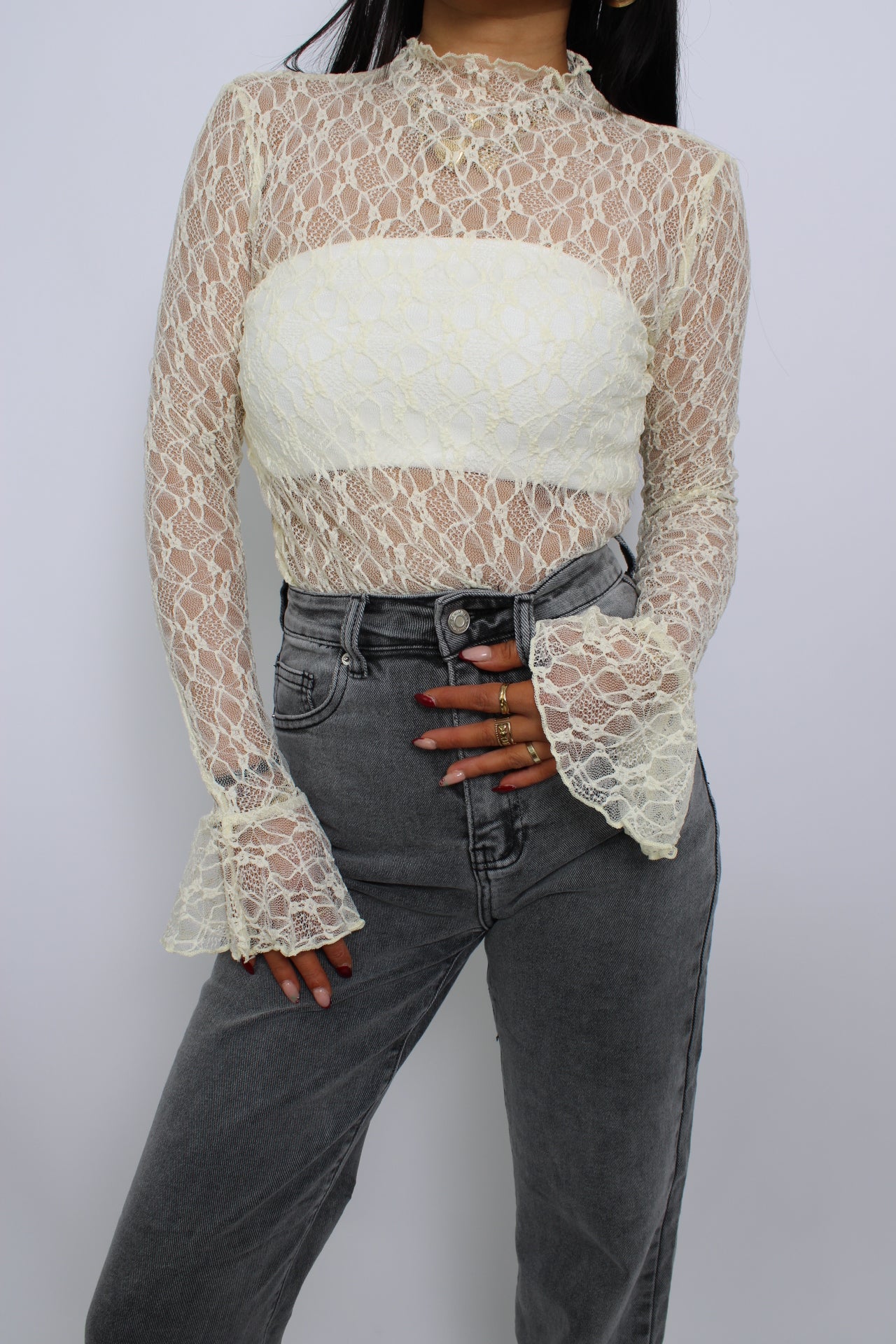 Een elegante kanten top met flare mouwen, een losse pasvorm en een verfijnde uitstraling. De top heeft een ronde halslijn en een delicate, doorzichtige stof voor een vrouwelijke look.