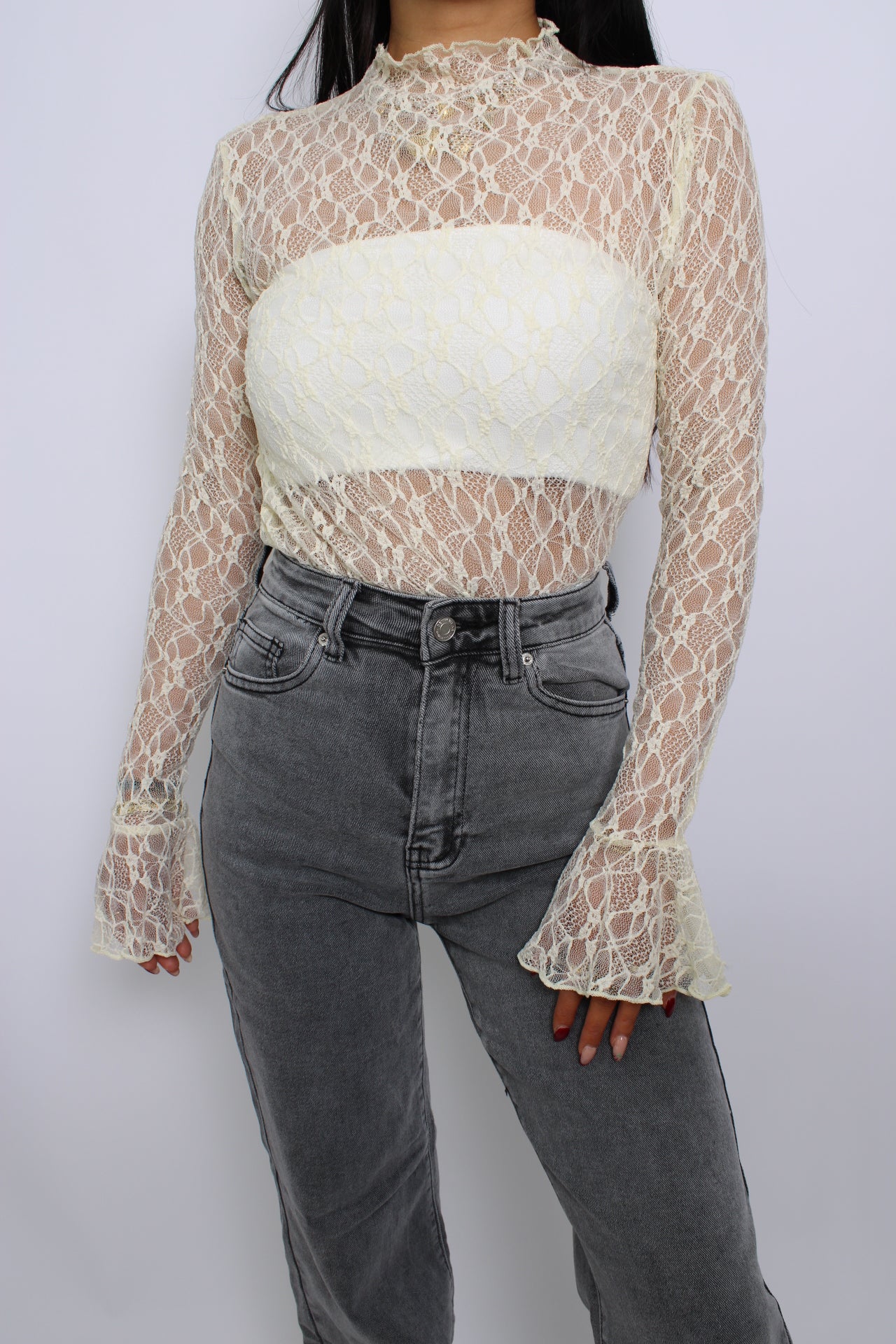 Een elegante kanten top met flare mouwen, een losse pasvorm en een verfijnde uitstraling. De top heeft een ronde halslijn en een delicate, doorzichtige stof voor een vrouwelijke look.
