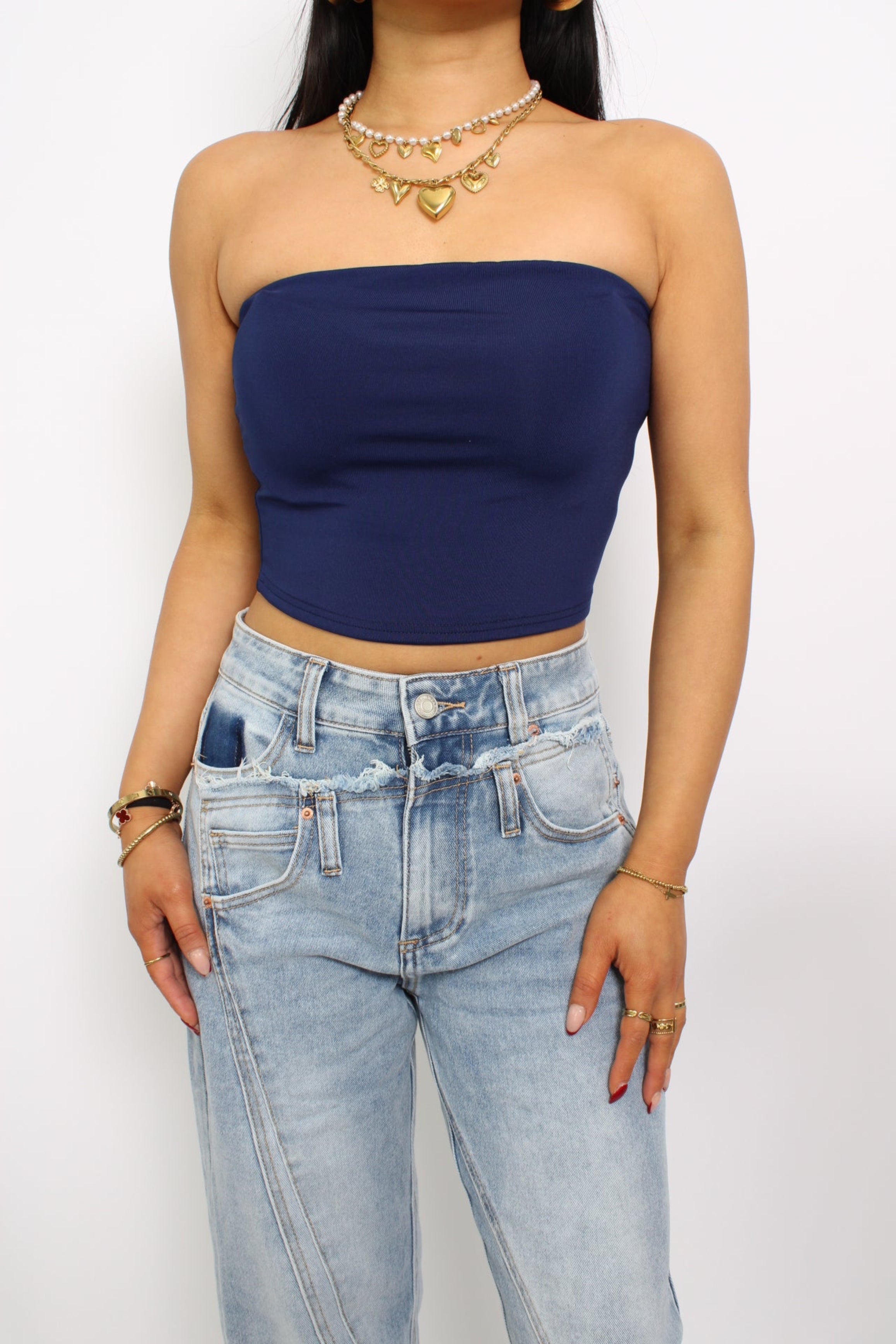 Een strapless tube top, gemaakt van elastische stof voor een comfortabele, nauwsluitende pasvorm. Het ontwerp heeft geen bandjes en valt net boven de taille voor een trendy en casual look.