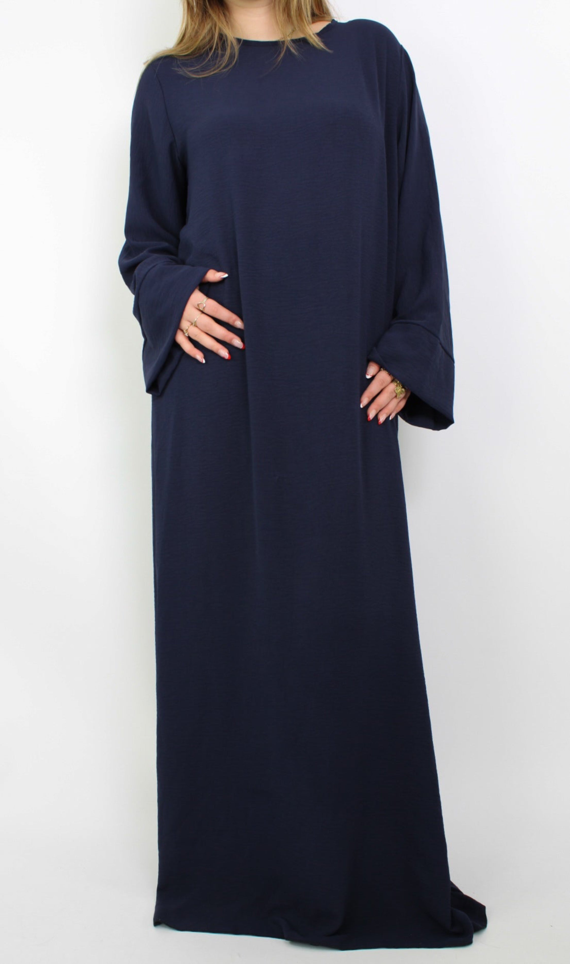 Hijabproof abaya jurk in een klassieke, elegante stijl. De jurk heeft een lange, vloeiende pasvorm met lange mouwen en een rechte snit, die zorgt voor een verfijnde uitstraling. Het lichte, ademende materiaal biedt zowel comfort als volledige dekking, perfect voor een modest look.
