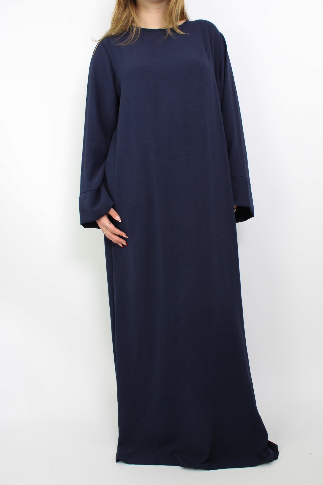 Hijabproof abaya jurk in een klassieke, elegante stijl. De jurk heeft een lange, vloeiende pasvorm met lange mouwen en een rechte snit, die zorgt voor een verfijnde uitstraling. Het lichte, ademende materiaal biedt zowel comfort als volledige dekking, perfect voor een modest look.