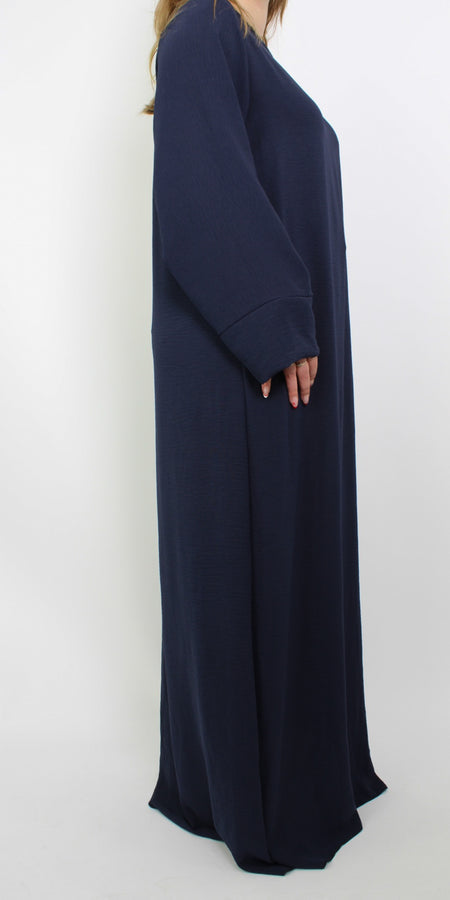 Hijabproof abaya jurk in een klassieke, elegante stijl. De jurk heeft een lange, vloeiende pasvorm met lange mouwen en een rechte snit, die zorgt voor een verfijnde uitstraling. Het lichte, ademende materiaal biedt zowel comfort als volledige dekking, perfect voor een modest look.