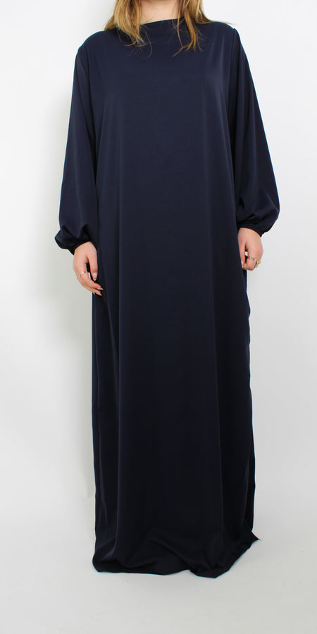 Tall hijabproof jurk in donkerblauw, met een lange, vloeiende pasvorm en een elegante ronde halslijn. De jurk heeft lange mouwen en biedt volledige dekking, ideaal voor een verfijnde, modest look. Het zachte, ademende materiaal zorgt voor comfort en bewegingsvrijheid.