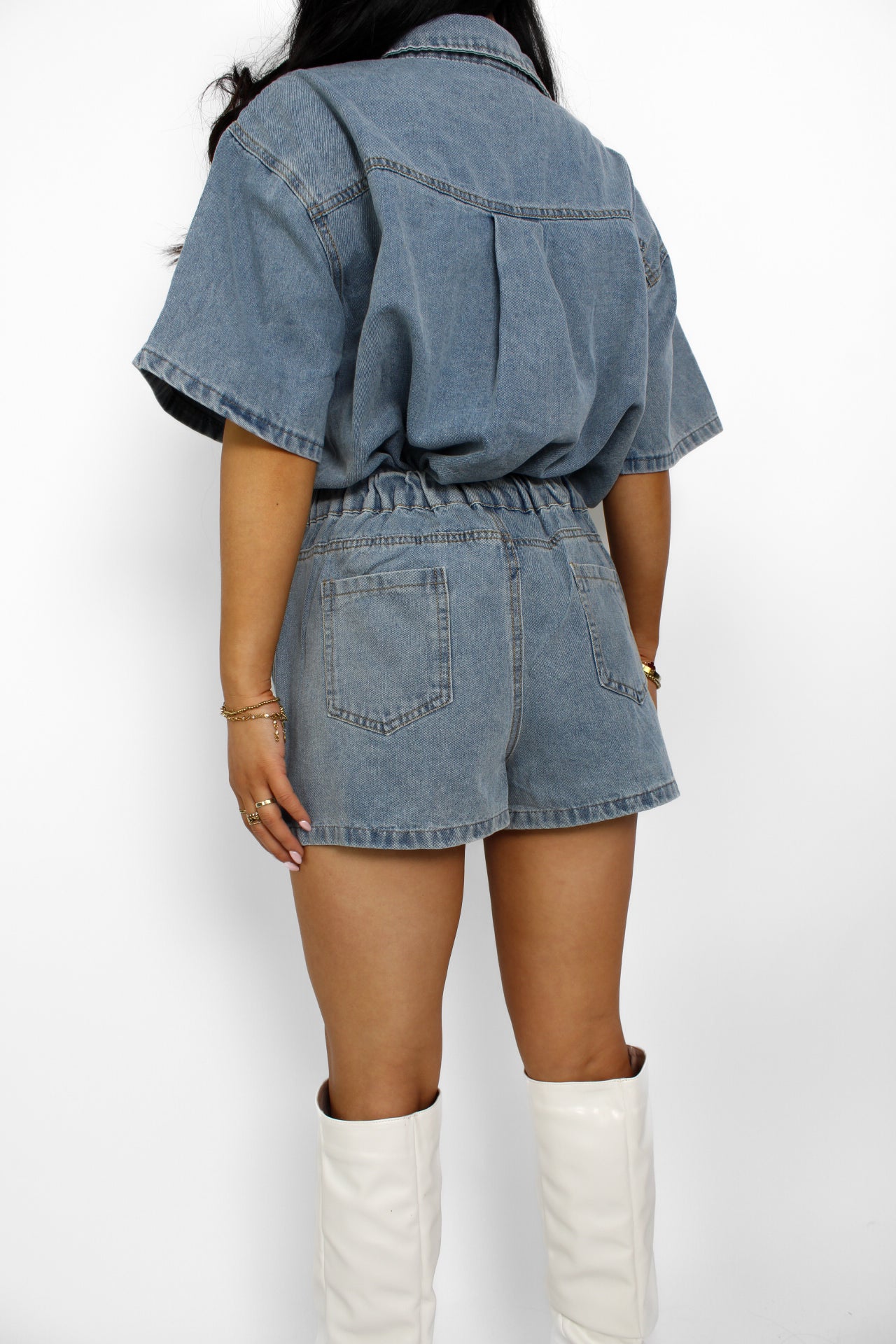 Een trendy denim 2-delig setje bestaande uit een korte top met knoopsluiting en een bijpassende skort. De skort heeft een A-lijn pasvorm met een subtiele rits aan de zijkant en een casual, veelzijdige uitstraling, perfect voor een zomerse look.