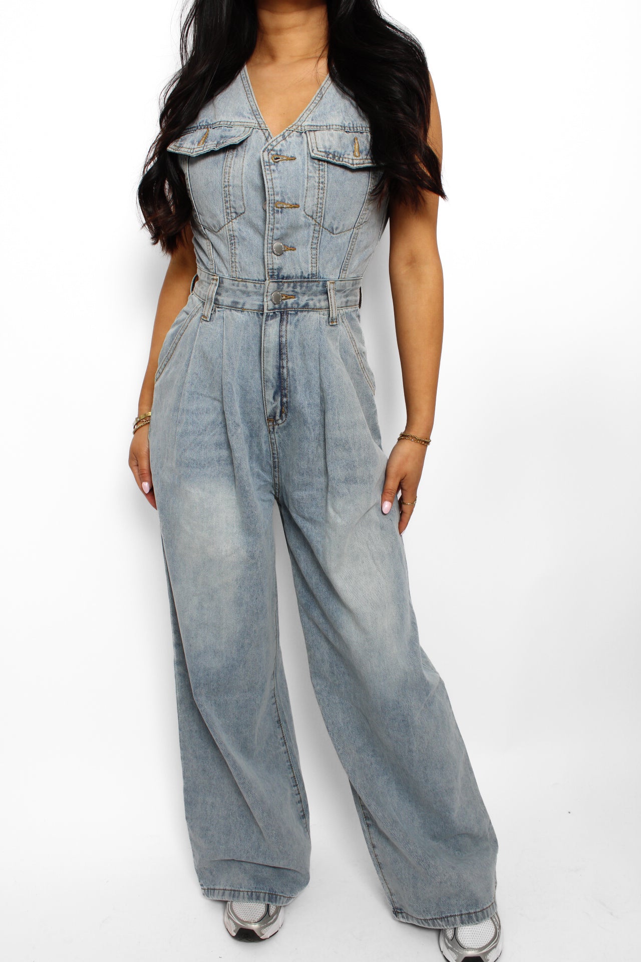 en stijlvolle denim jumpsuit met een rechte pasvorm, knoopsluiting aan de voorkant en een tailleband voor extra vorm. De jumpsuit heeft korte mouwen en is gemaakt van een middelzware denim stof, ideaal voor een casual en tijdloze look.