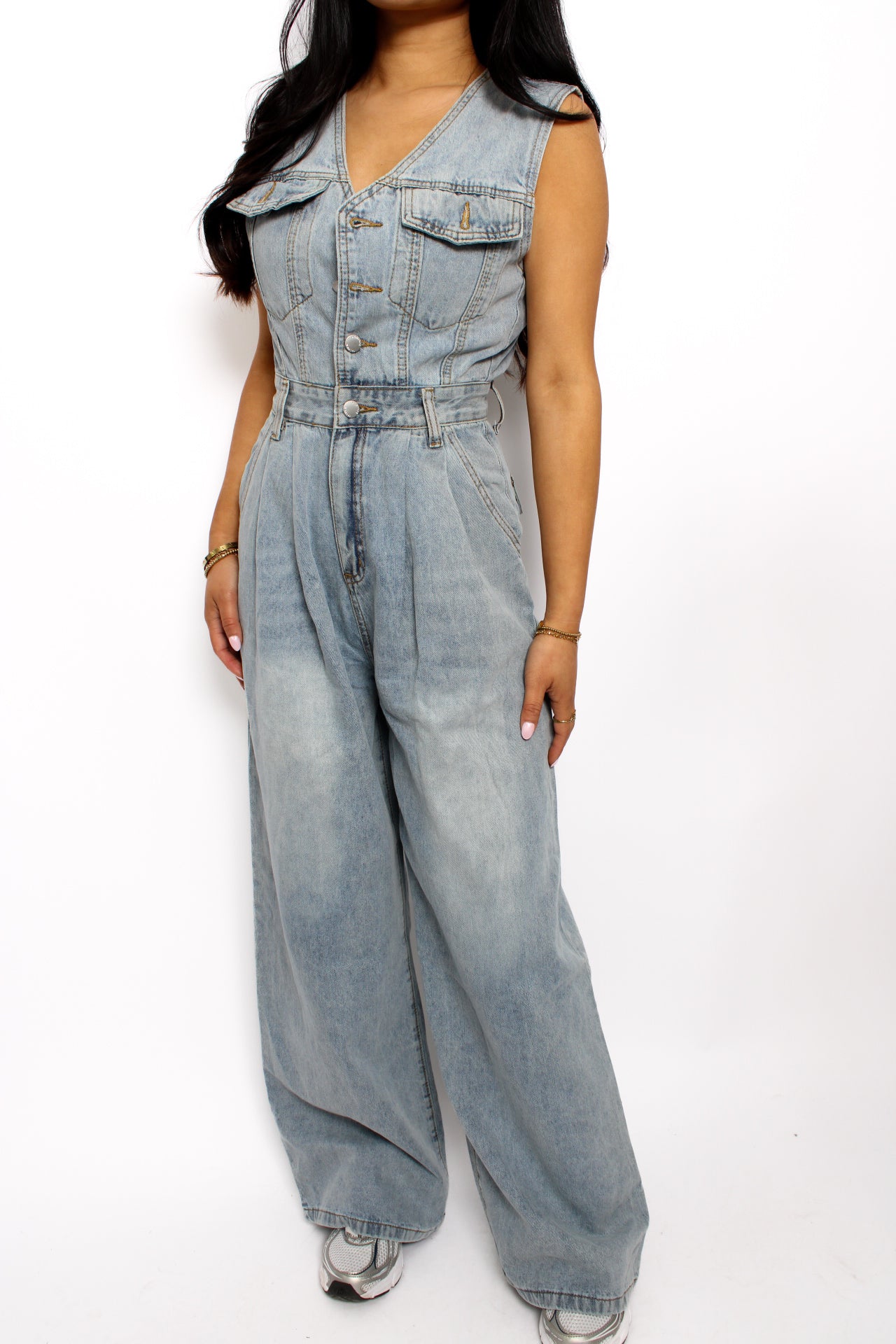 en stijlvolle denim jumpsuit met een rechte pasvorm, knoopsluiting aan de voorkant en een tailleband voor extra vorm. De jumpsuit heeft korte mouwen en is gemaakt van een middelzware denim stof, ideaal voor een casual en tijdloze look.
