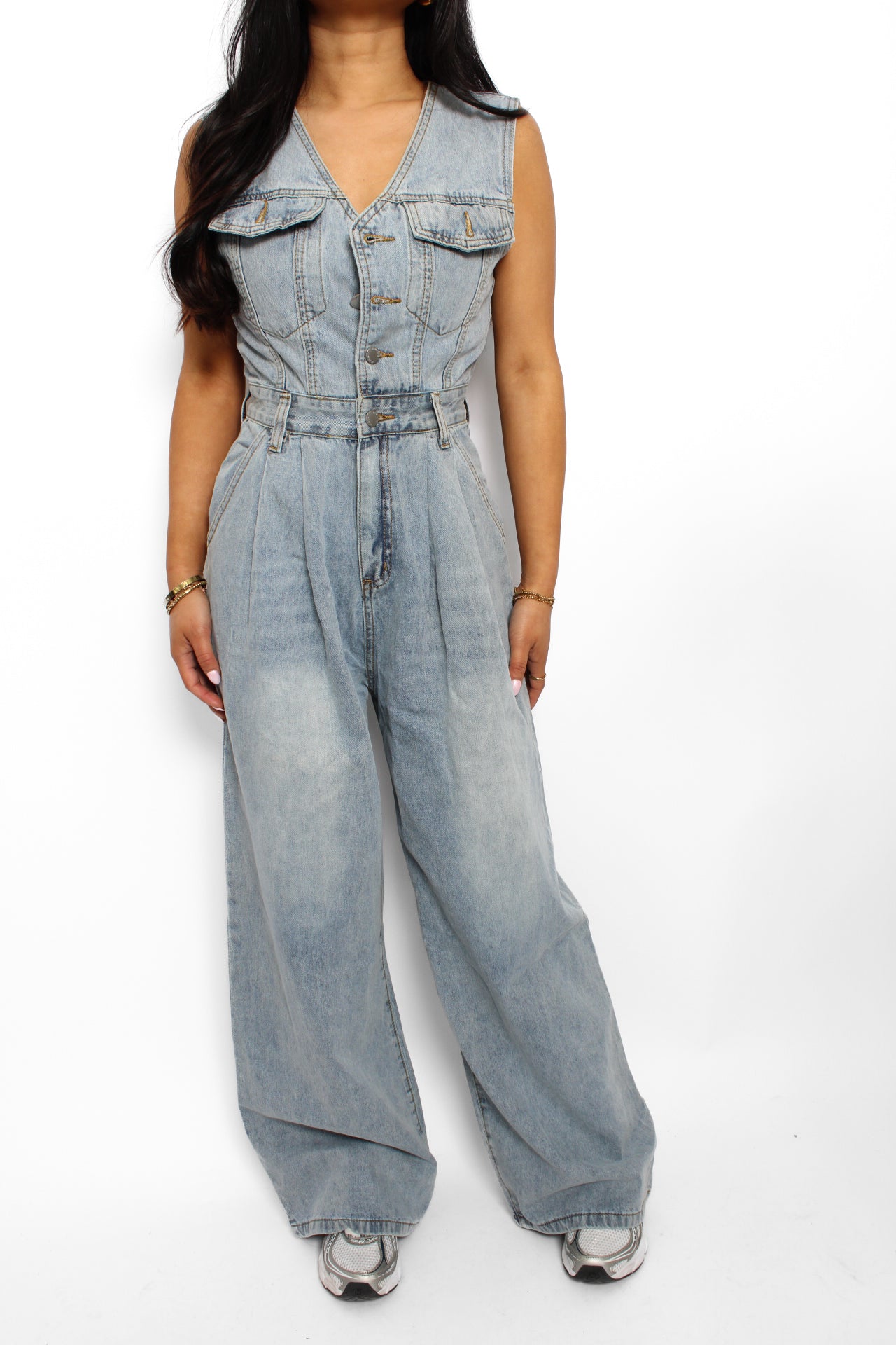 en stijlvolle denim jumpsuit met een rechte pasvorm, knoopsluiting aan de voorkant en een tailleband voor extra vorm. De jumpsuit heeft korte mouwen en is gemaakt van een middelzware denim stof, ideaal voor een casual en tijdloze look.
