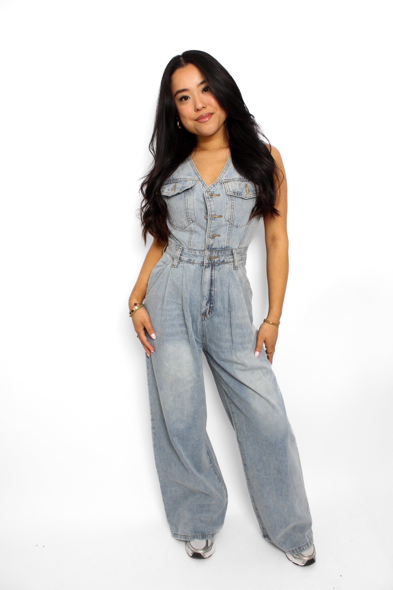 en stijlvolle denim jumpsuit met een rechte pasvorm, knoopsluiting aan de voorkant en een tailleband voor extra vorm. De jumpsuit heeft korte mouwen en is gemaakt van een middelzware denim stof, ideaal voor een casual en tijdloze look.