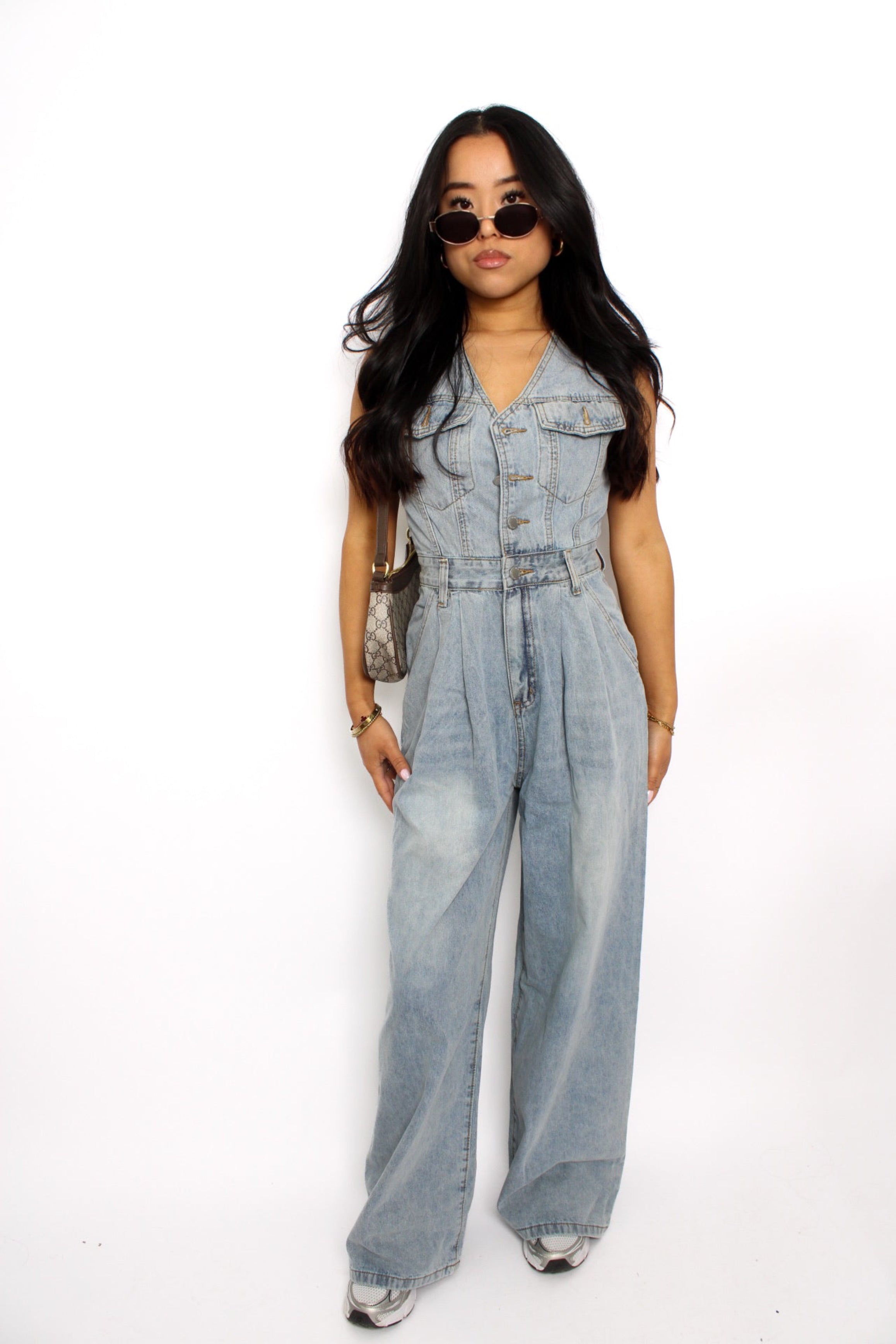 en stijlvolle denim jumpsuit met een rechte pasvorm, knoopsluiting aan de voorkant en een tailleband voor extra vorm. De jumpsuit heeft korte mouwen en is gemaakt van een middelzware denim stof, ideaal voor een casual en tijdloze look.