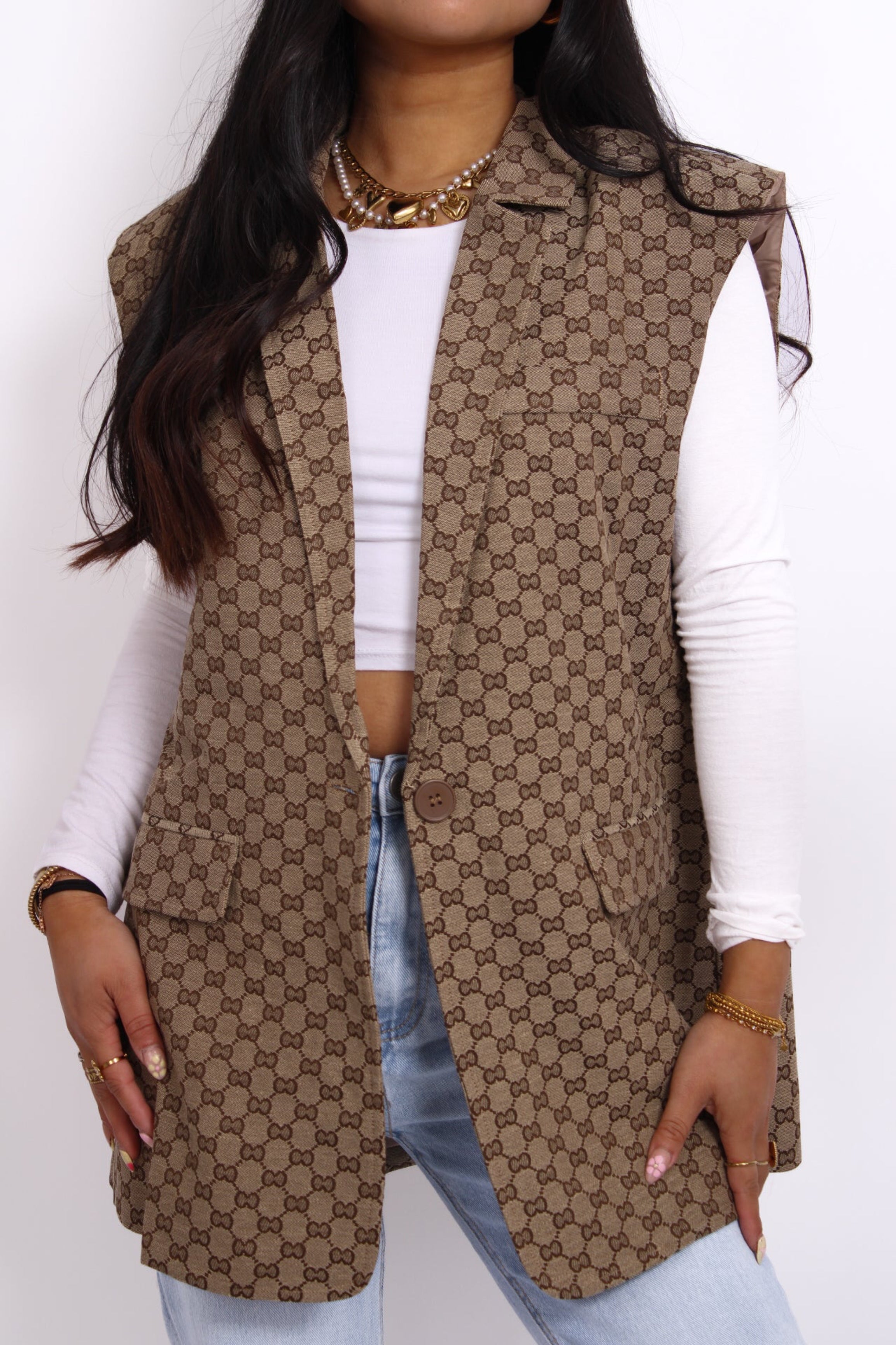 bruine  gilet met subtiel geborduurd logo op de borst, mouwloos design en een getailleerde pasvorm.