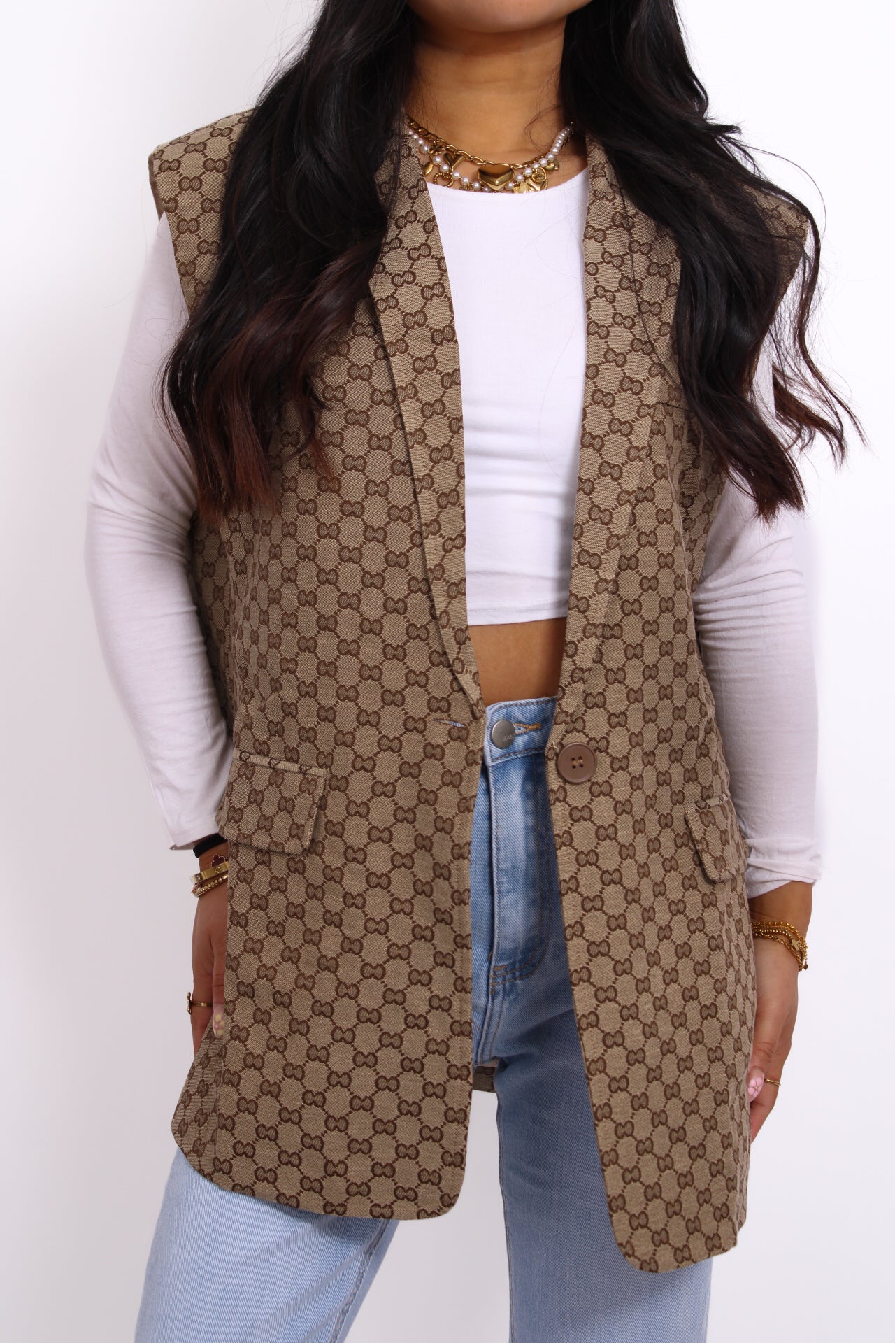 bruine  gilet met subtiel geborduurd logo op de borst, mouwloos design en een getailleerde pasvorm.
