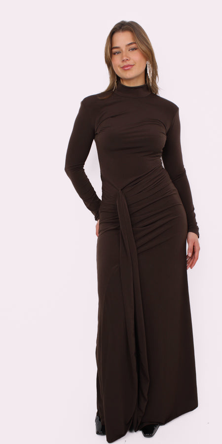 Deze prachtige maxi jurk heeft een speelse split aan je rechterbeen, waardoor hij meteen iets flirterigs krijgt. De iets hogere halslijn geeft ’m net dat stijlvolle randje, terwijl de gedrapeerde taille je figuur mooi volgt zonder strak te zitten. De stof valt soepel en geeft de jurk een romantische, effortless vibe.