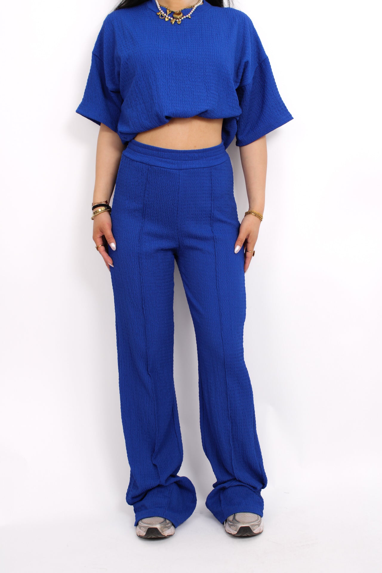 Zomerse outfit voor lange vrouwen: lichte top met een wijde, lange broek die goed past bij langere benen