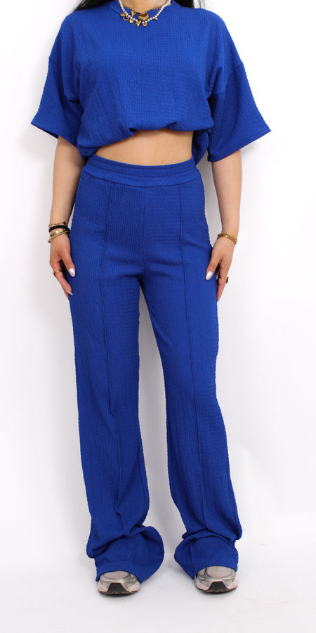 Zomerse outfit voor lange vrouwen: lichte top met een wijde, lange broek die goed past bij langere benen