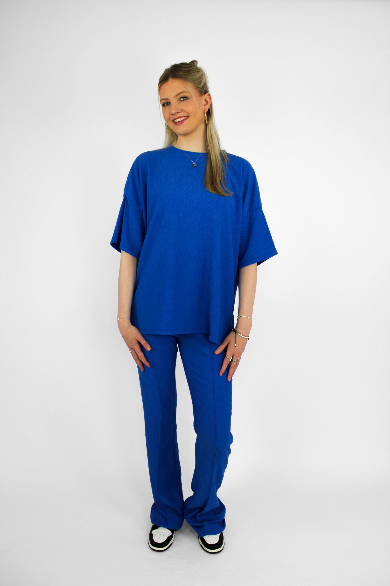 Zomerse outfit voor lange vrouwen: lichte top met een wijde, lange broek die goed past bij langere benen