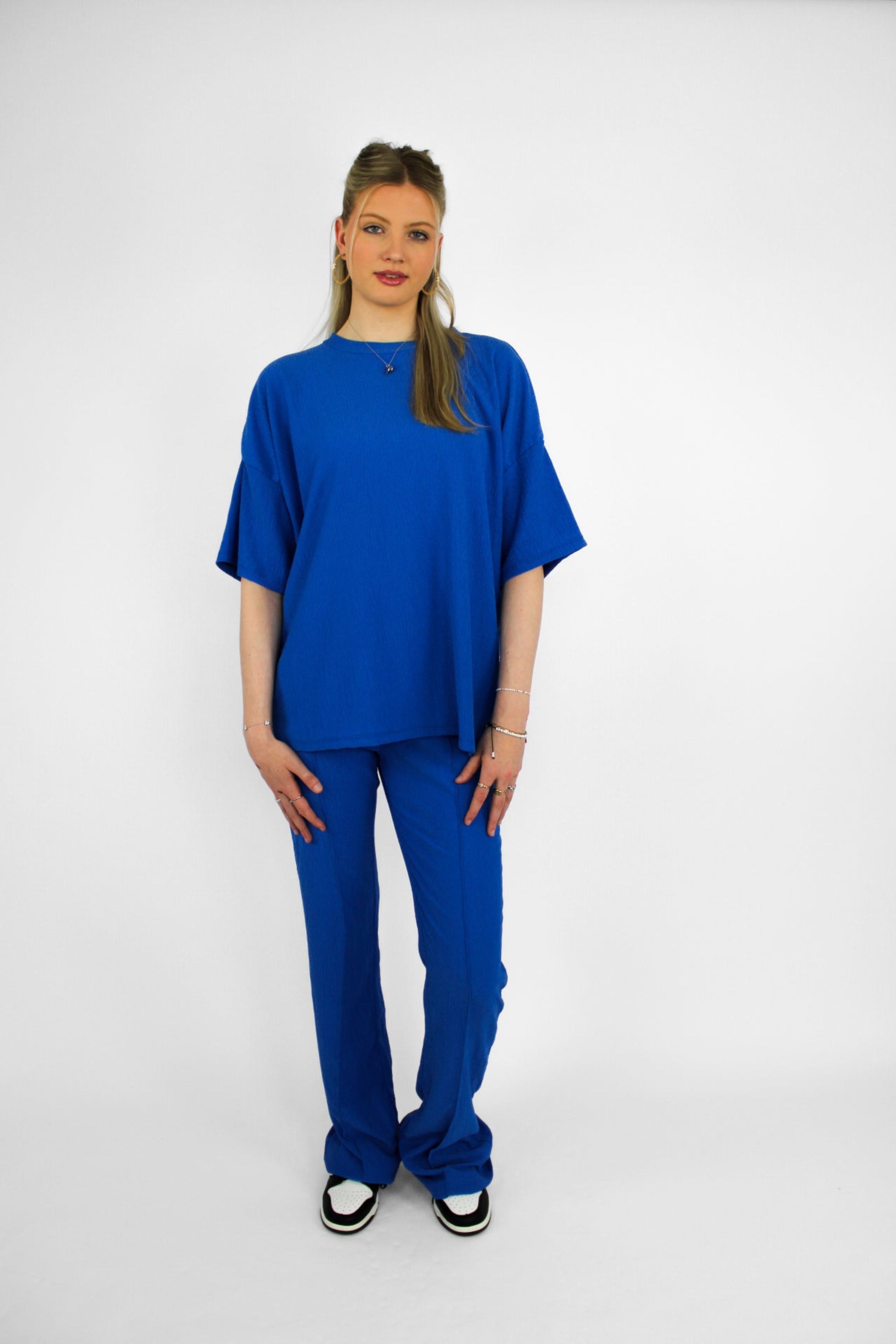 Zomerse outfit voor lange vrouwen: lichte top met een wijde, lange broek die goed past bij langere benen