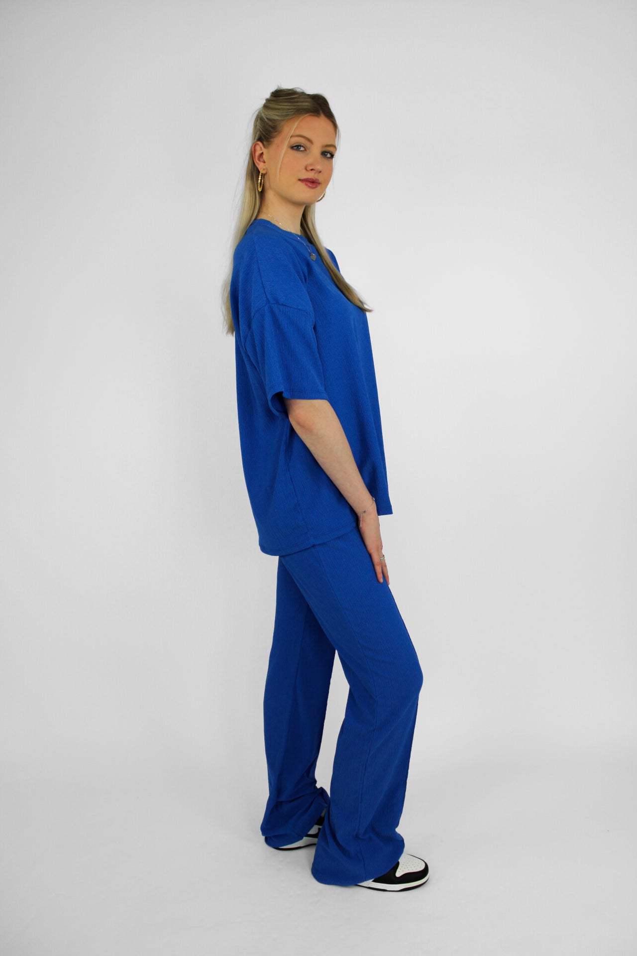 Zomerse outfit voor lange vrouwen: lichte top met een wijde, lange broek die goed past bij langere benen
