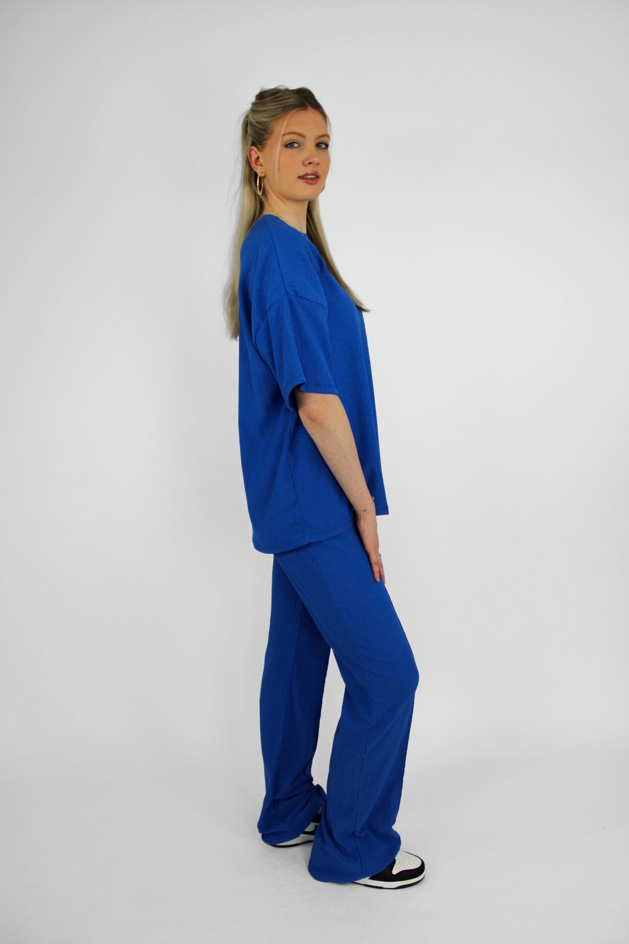 Zomerse outfit voor lange vrouwen: lichte top met een wijde, lange broek die goed past bij langere benen