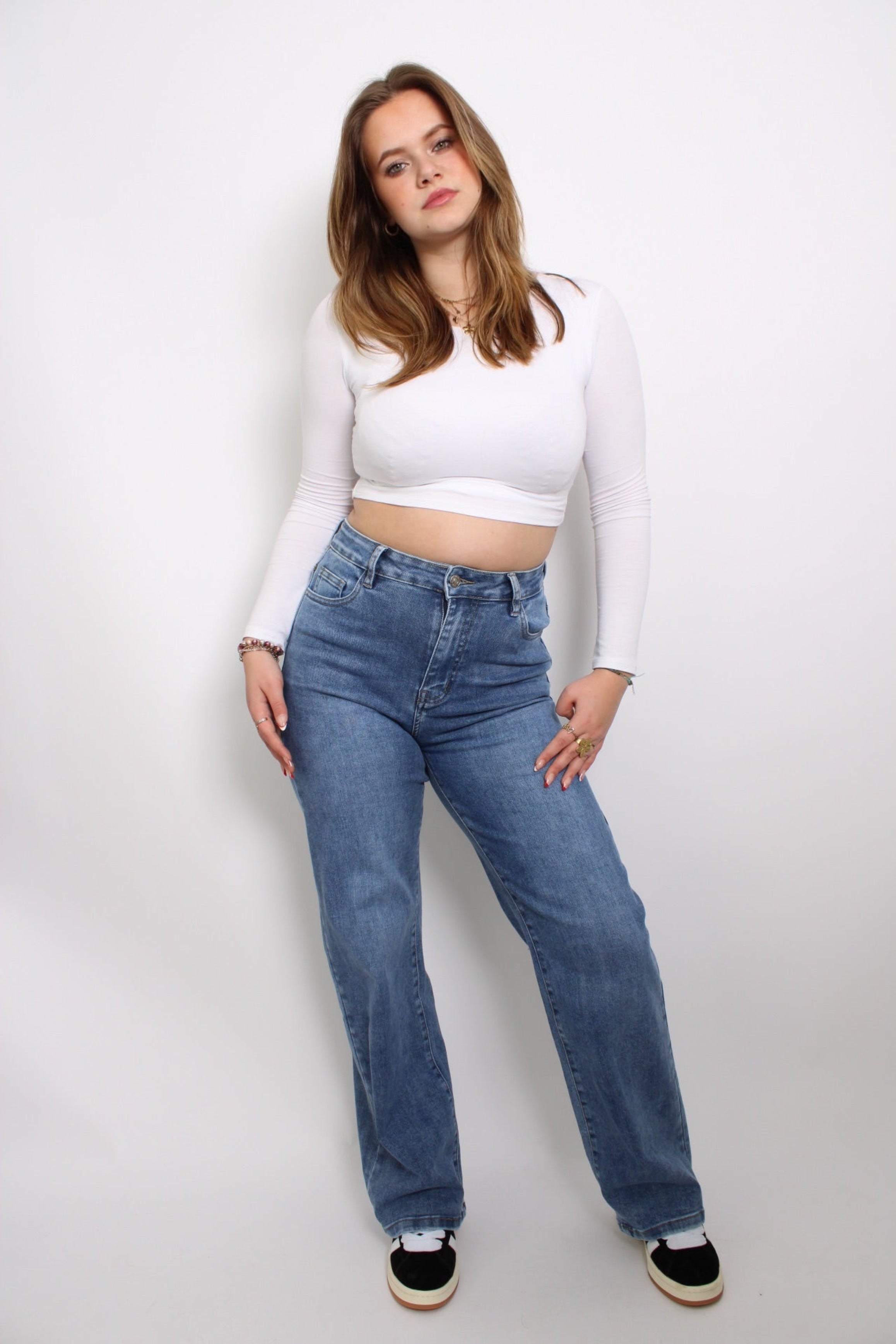 Plus-size donker denim jeans met een klassieke pasvorm en een subtiele wassing. De jeans heeft een comfortabele taille en rechte pijpen, waardoor het een tijdloze en veelzijdige keuze is voor verschillende outfits. Het stevige denim biedt zowel steun als stijl voor een flatterende look.