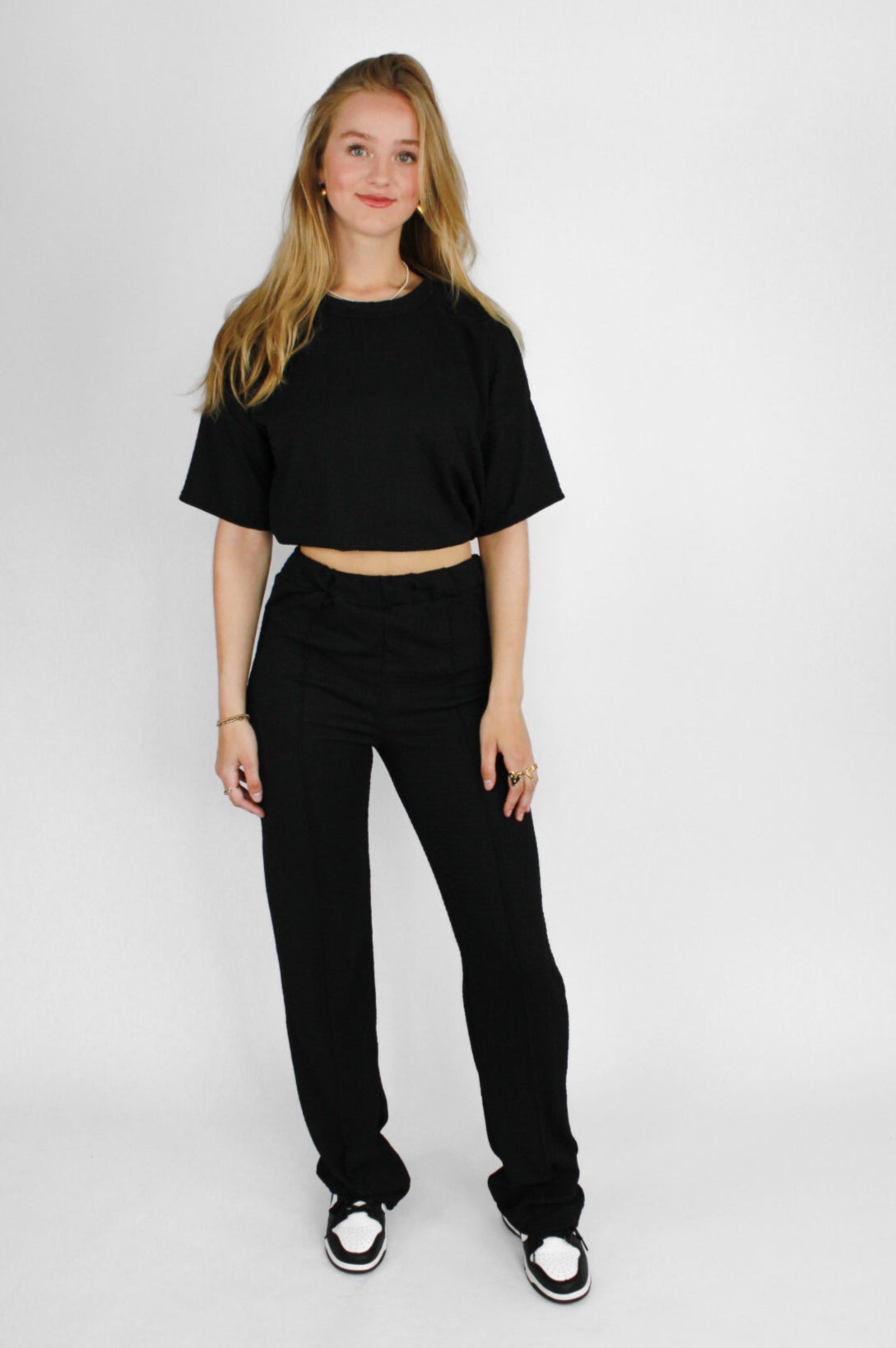 Zomerse outfit voor lange vrouwen: lichte top met een wijde, lange broek die goed past bij langere benen