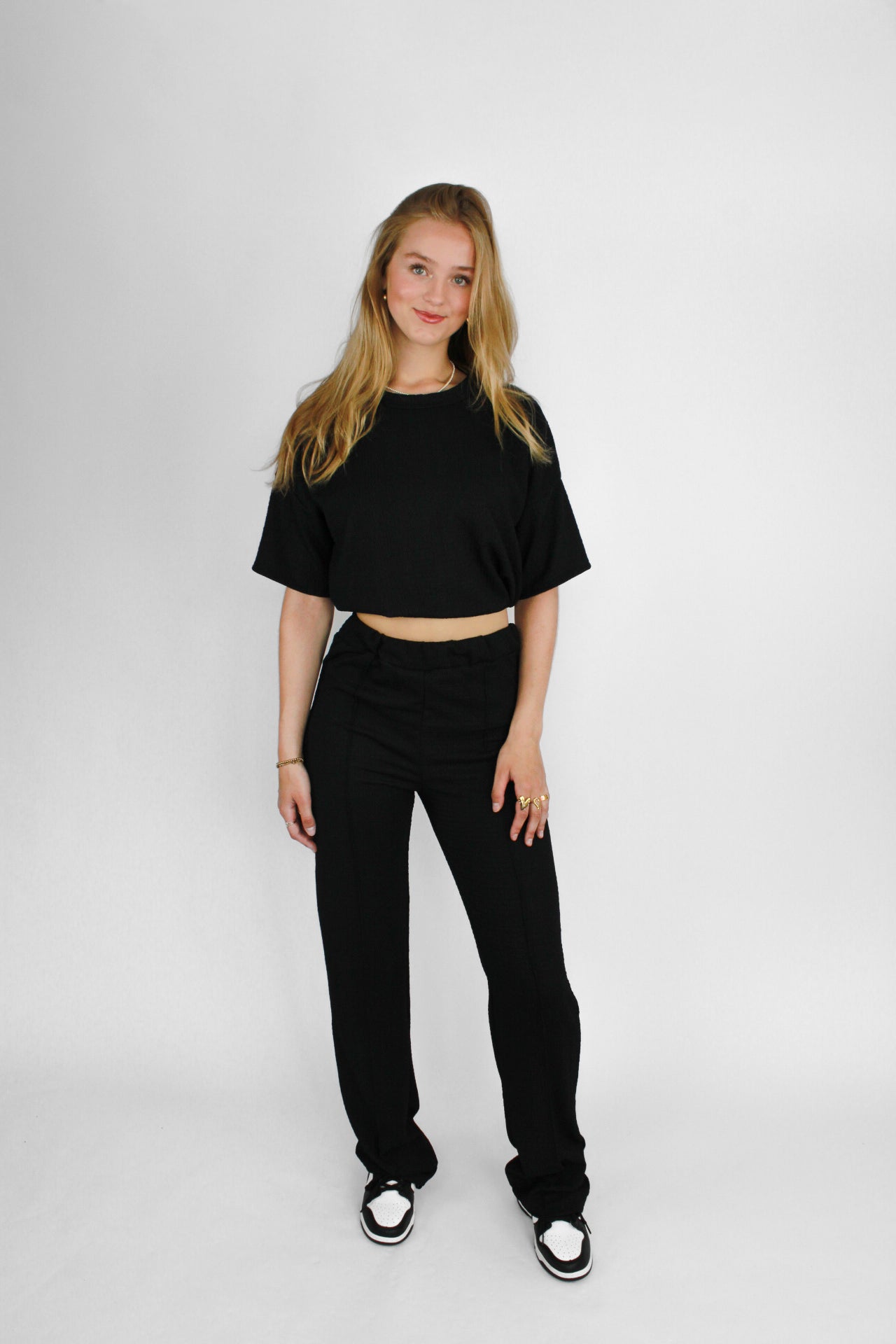 Zomerse outfit voor lange vrouwen: lichte top met een wijde, lange broek die goed past bij langere benen
