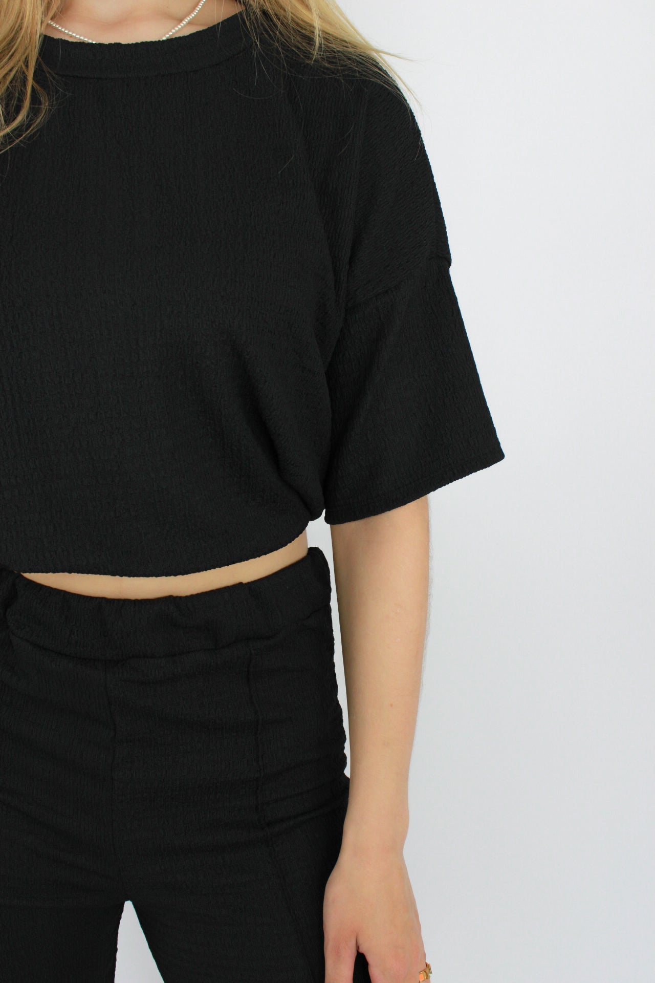 Zomerse outfit voor lange vrouwen: lichte top met een wijde, lange broek die goed past bij langere benen