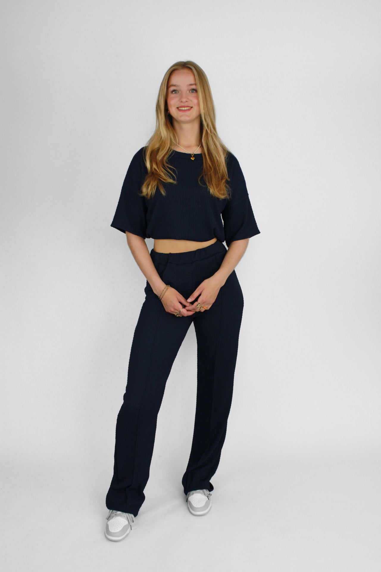 Zomerse outfit voor lange vrouwen: lichte top met een wijde, lange broek die goed past bij langere benen