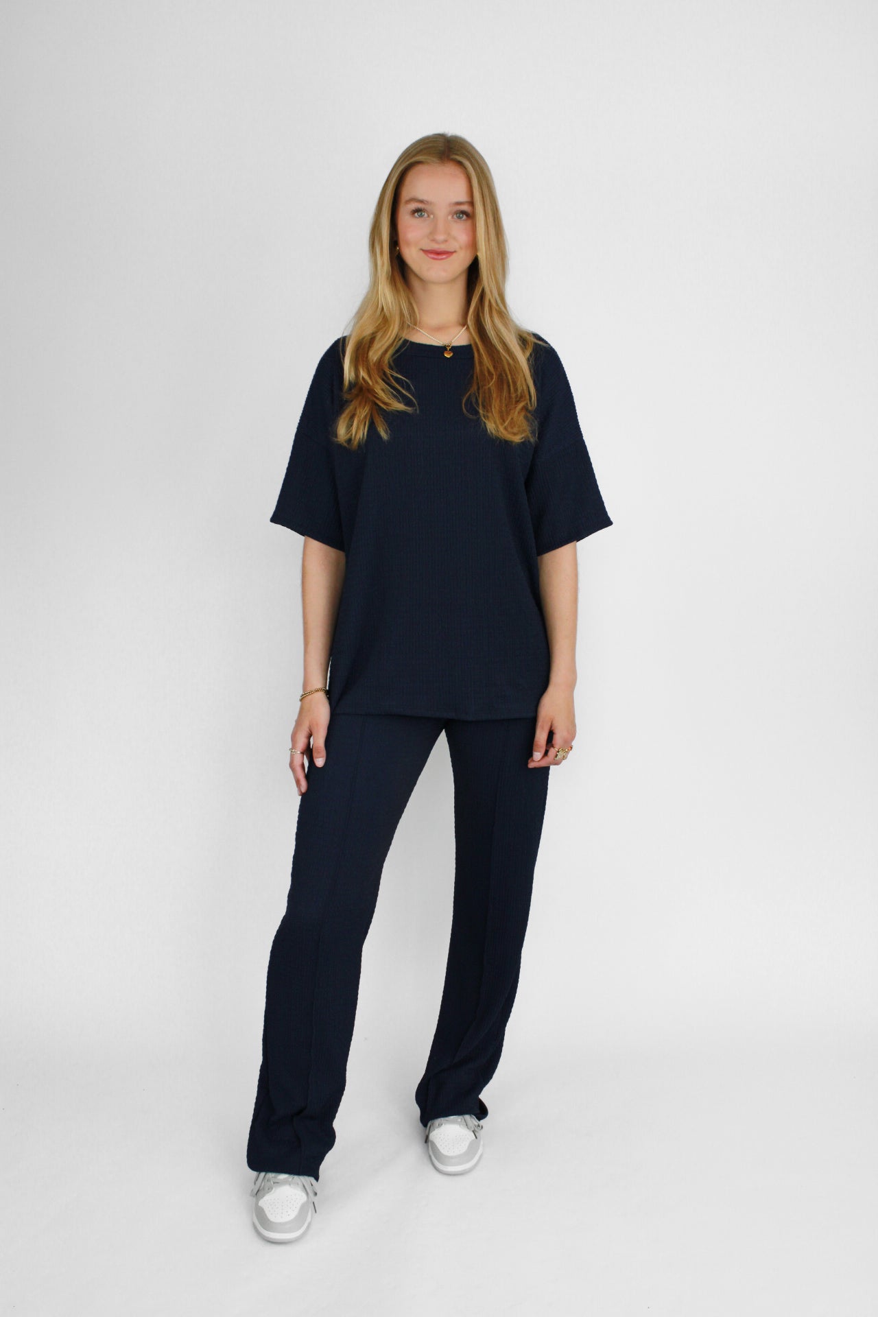 Zomerse outfit voor lange vrouwen: lichte top met een wijde, lange broek die goed past bij langere benen