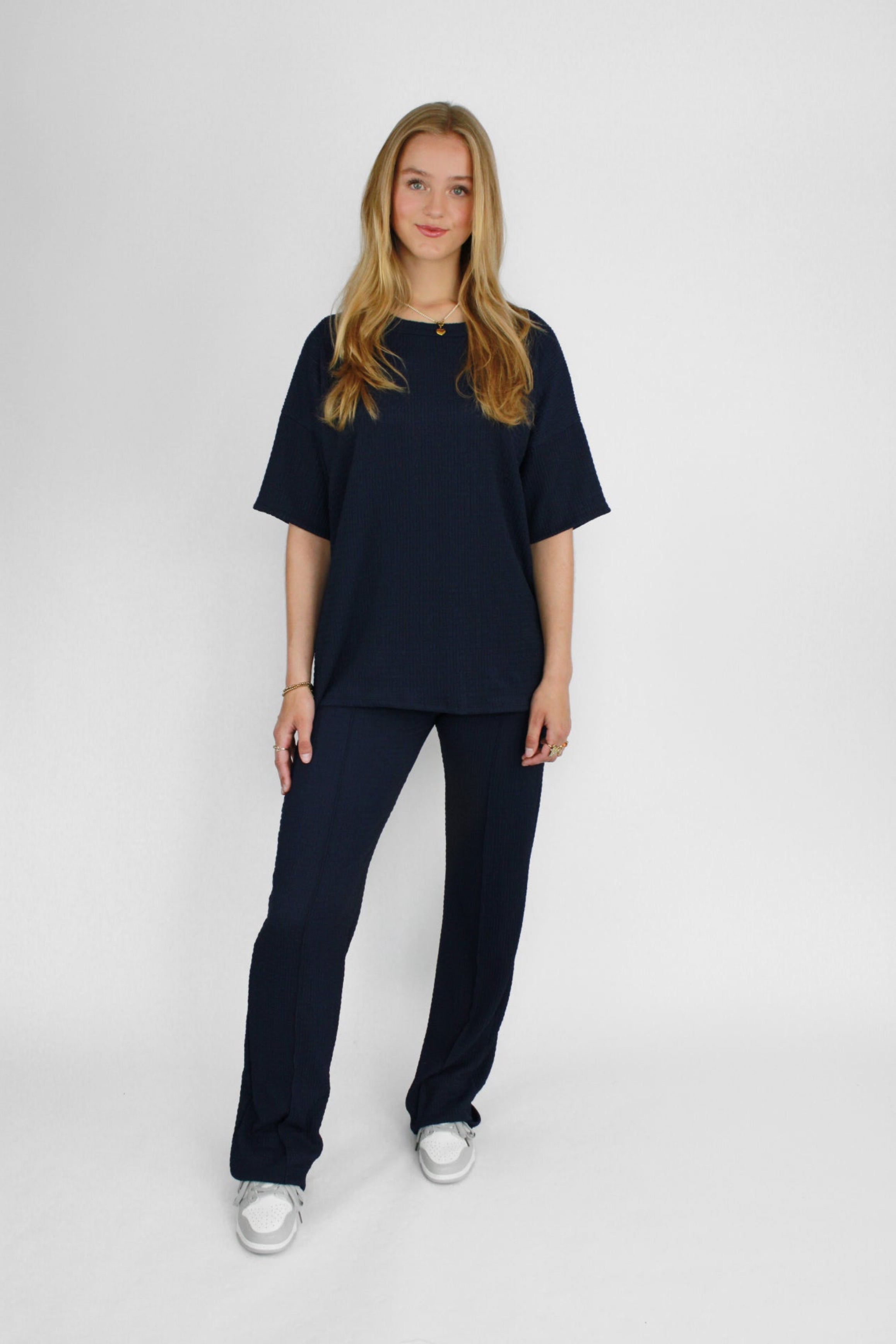 Zomerse outfit voor lange vrouwen: lichte top met een wijde, lange broek die goed past bij langere benen