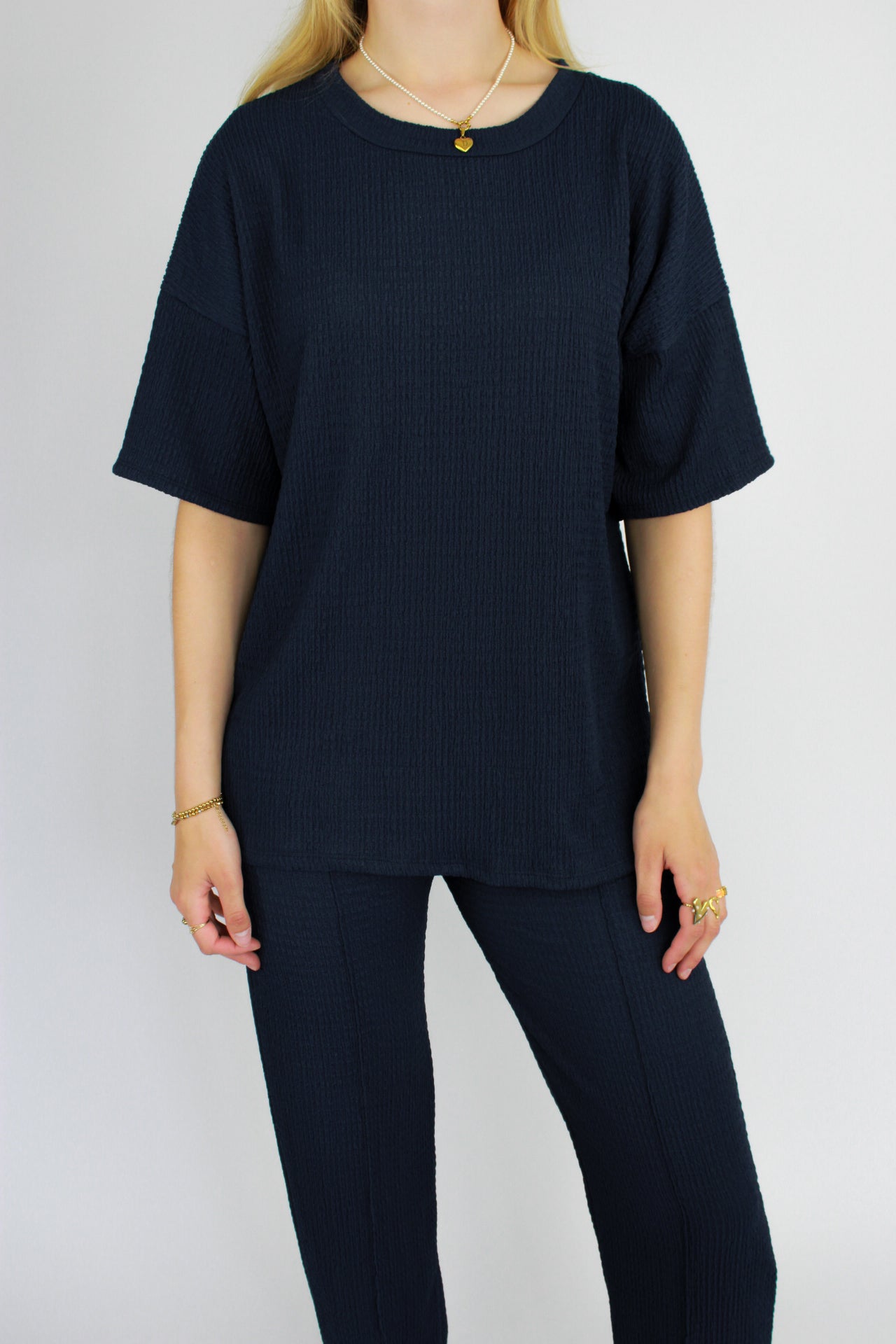 Zomerse outfit voor lange vrouwen: lichte top met een wijde, lange broek die goed past bij langere benen
