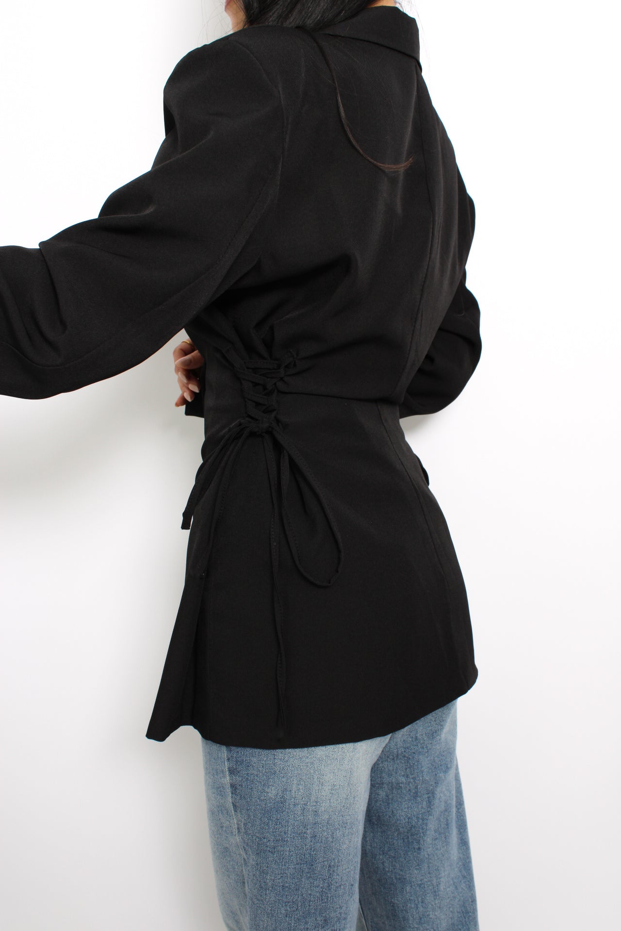 Zwarte blazer met touwdetails aan de zijkanten voor een getailleerde pasvorm.