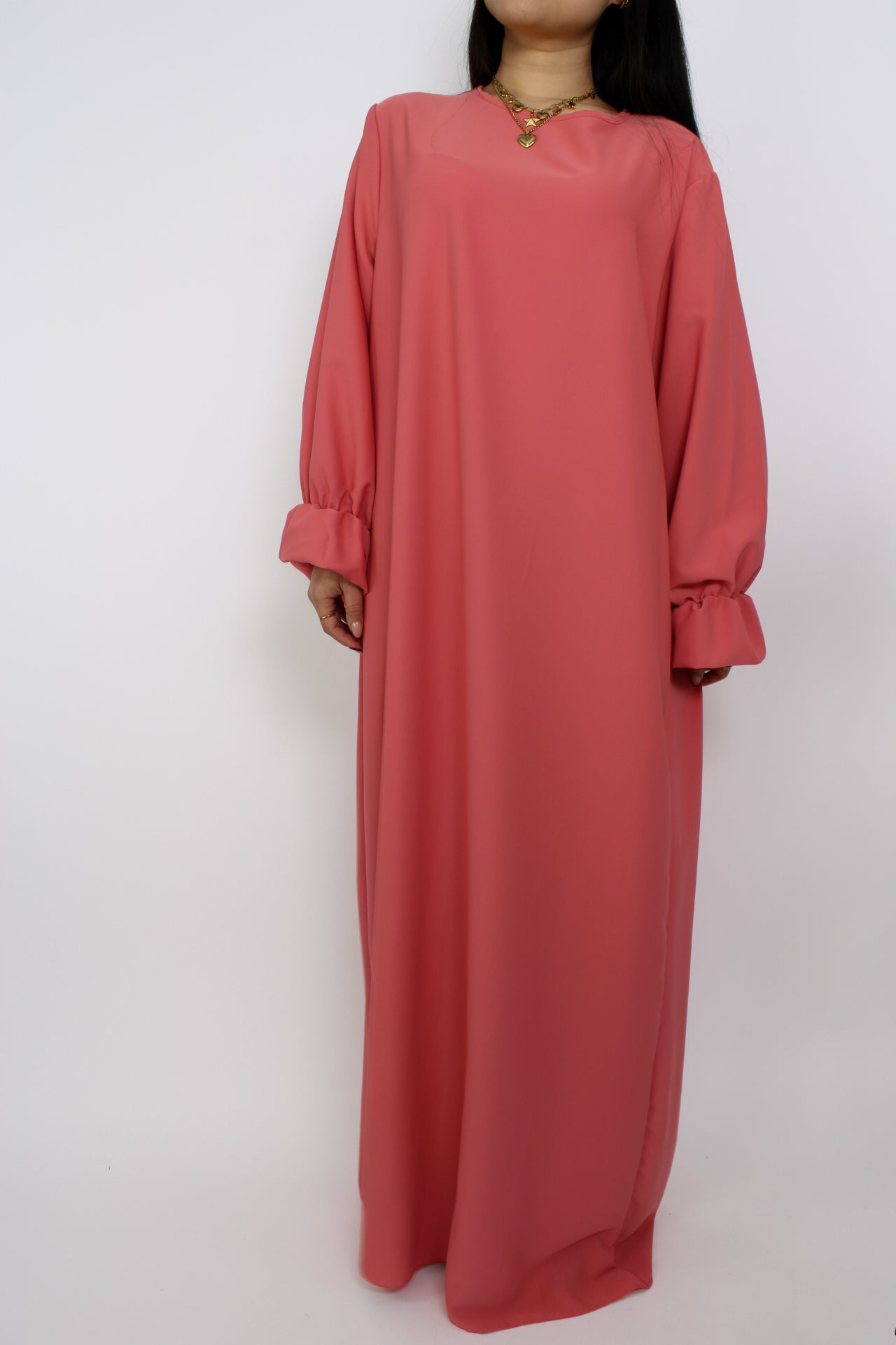 Stijlvolle, lange jurk met een losse pasvorm, ontworpen om comfortabel te dragen met een hijab, met een bescheiden halslijn en mouwen.