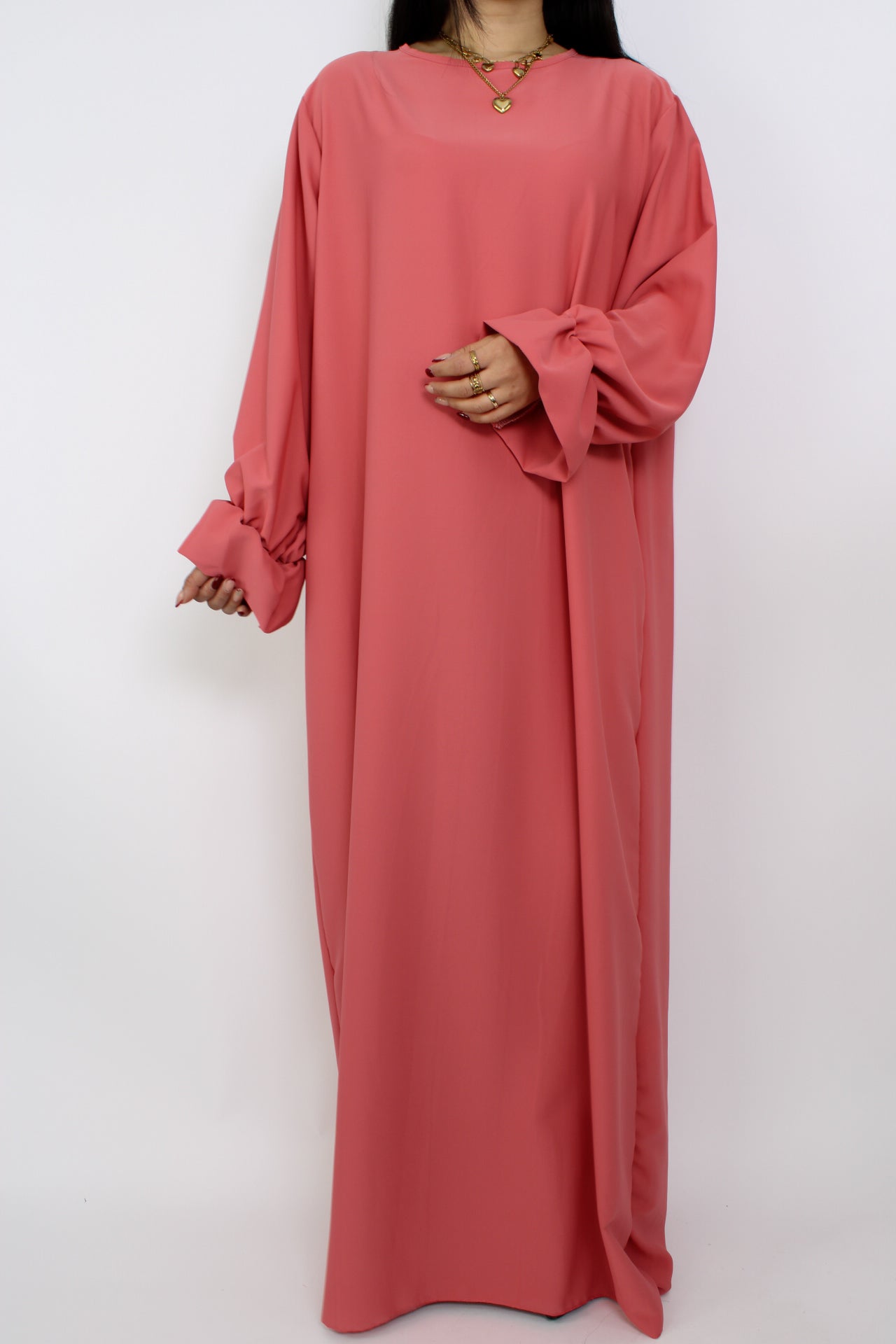 Stijlvolle, lange jurk met een losse pasvorm, ontworpen om comfortabel te dragen met een hijab, met een bescheiden halslijn en mouwen.