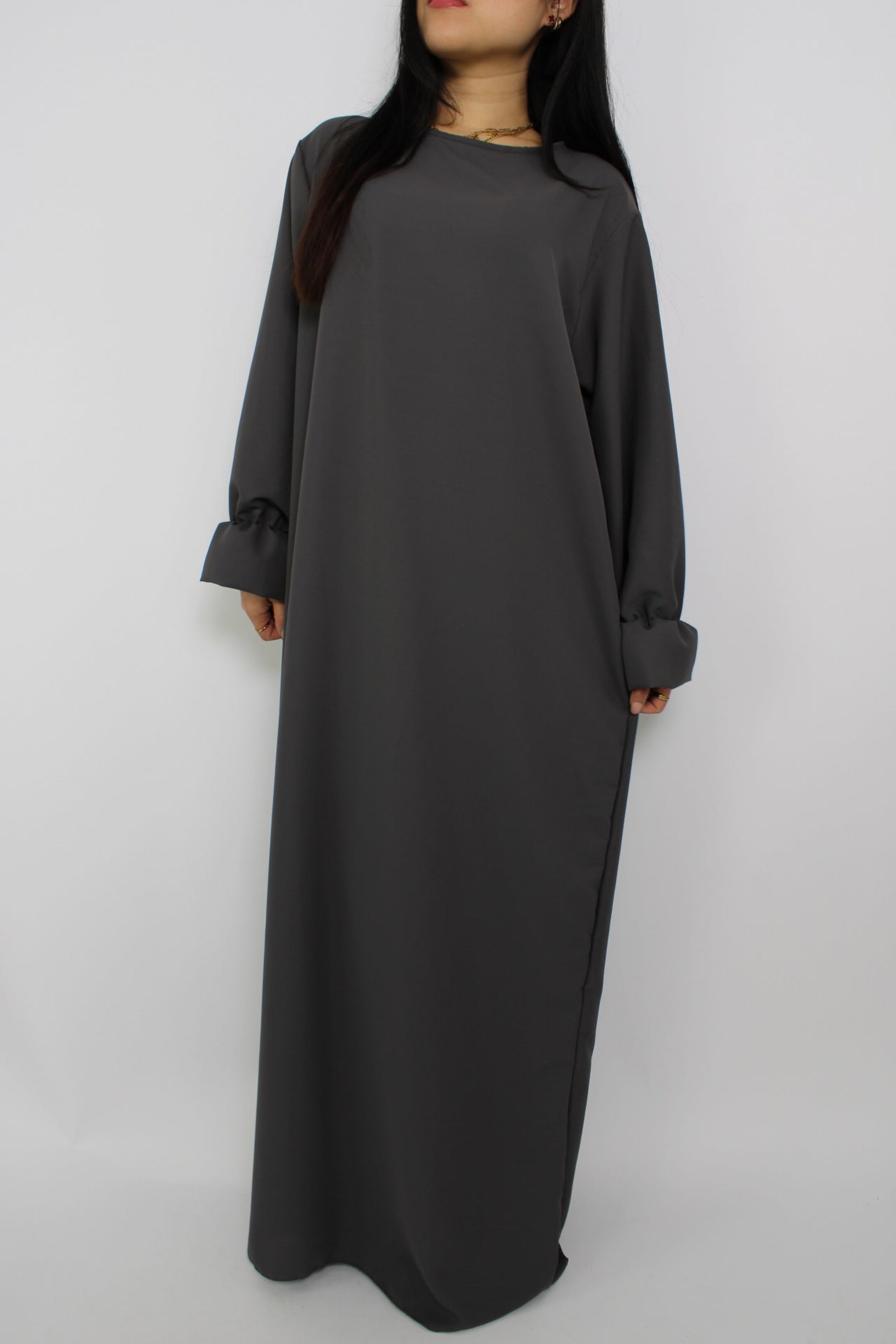 Stijlvolle, lange jurk met een losse pasvorm, ontworpen om comfortabel te dragen met een hijab, met een bescheiden halslijn en mouwen. Satijnen abaya