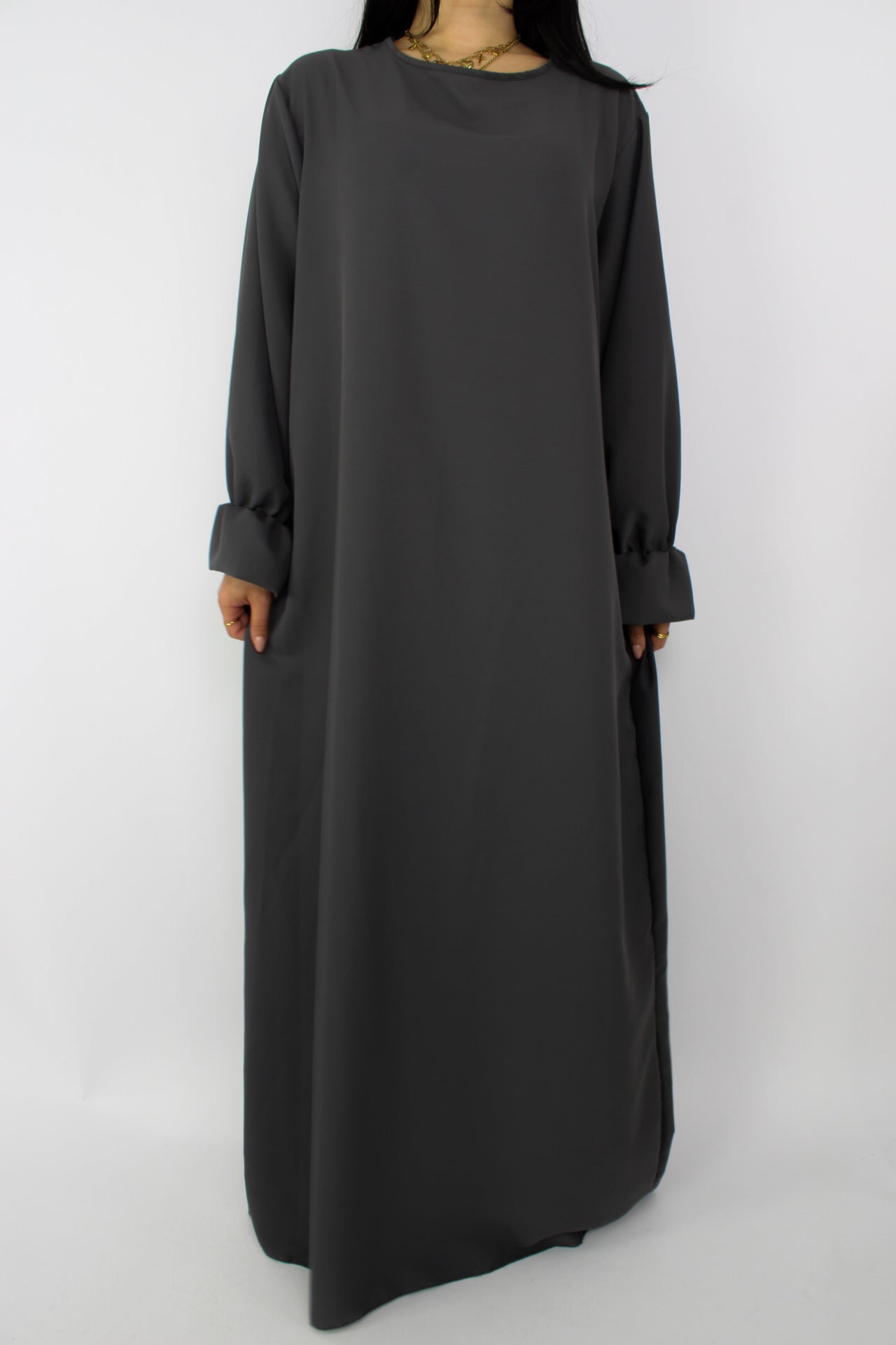 Stijlvolle, lange jurk met een losse pasvorm, ontworpen om comfortabel te dragen met een hijab, met een bescheiden halslijn en mouwen. Satijnen abaya