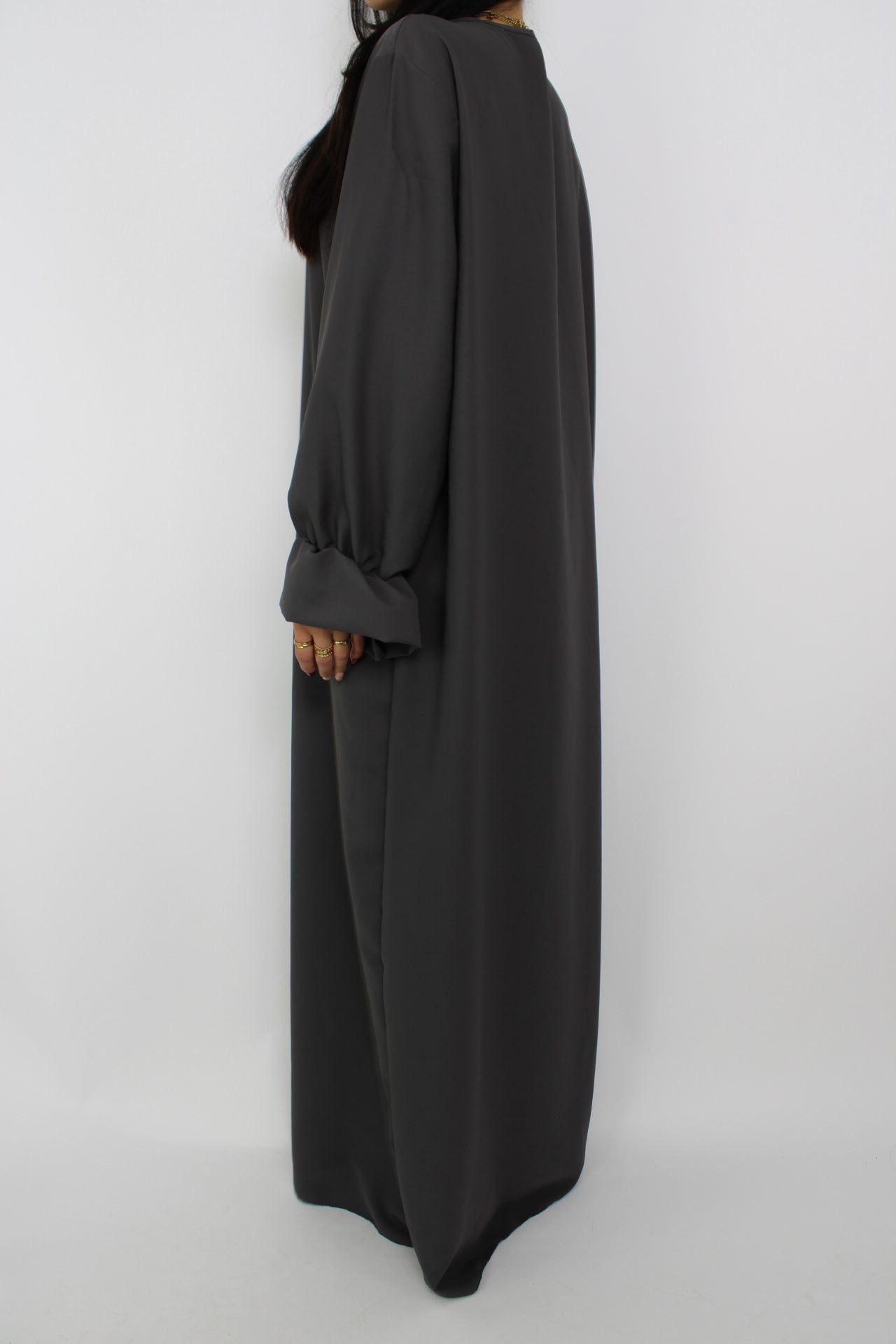 Stijlvolle, lange jurk met een losse pasvorm, ontworpen om comfortabel te dragen met een hijab, met een bescheiden halslijn en mouwen. Satijnen abaya