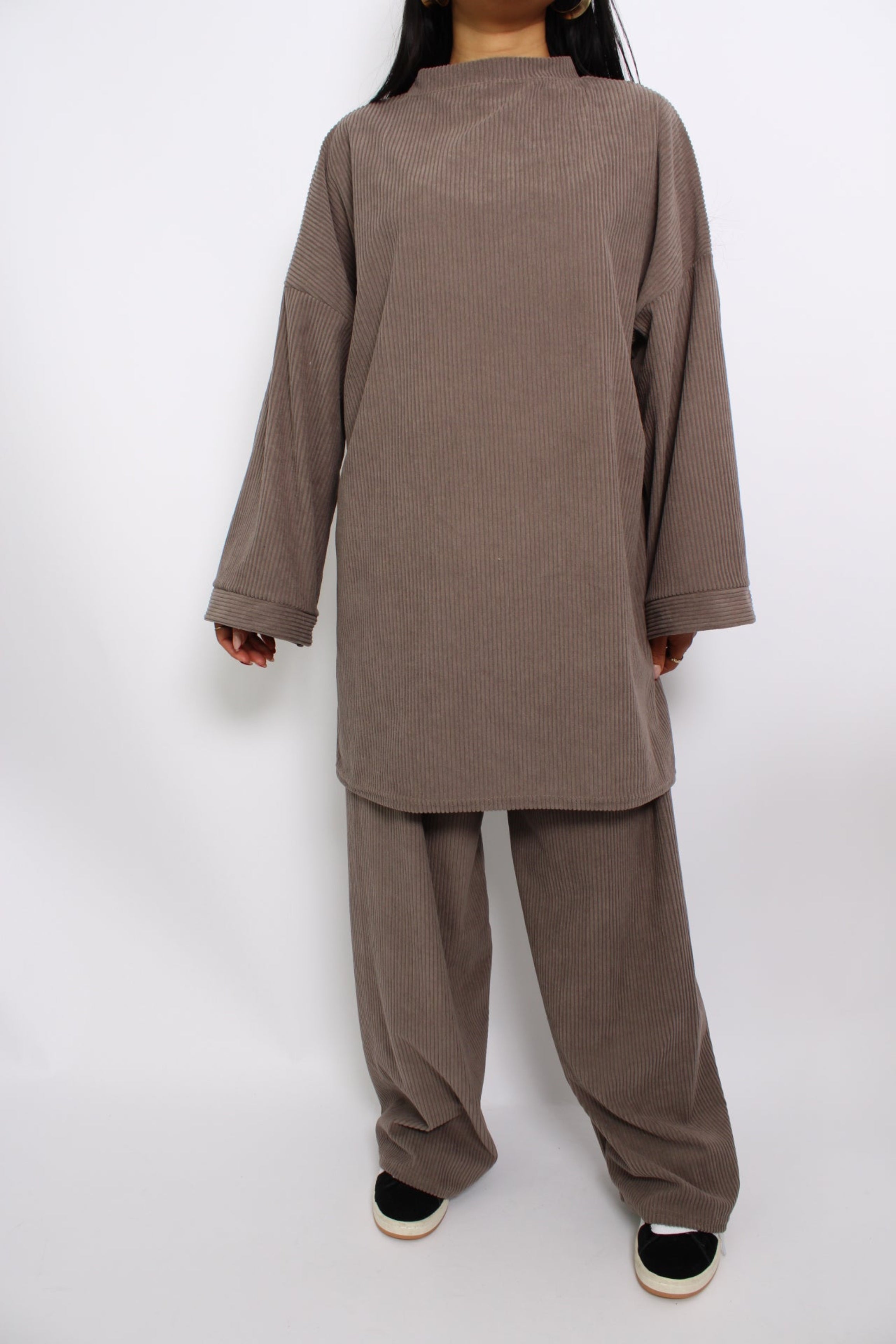 Een hijabproof tweedelige set van corduroy, bestaande uit een lange, losse top met lange mouwen en een bijpassende broek. De stof is comfortabel en ademend, met een tijdloze, elegante uitstraling