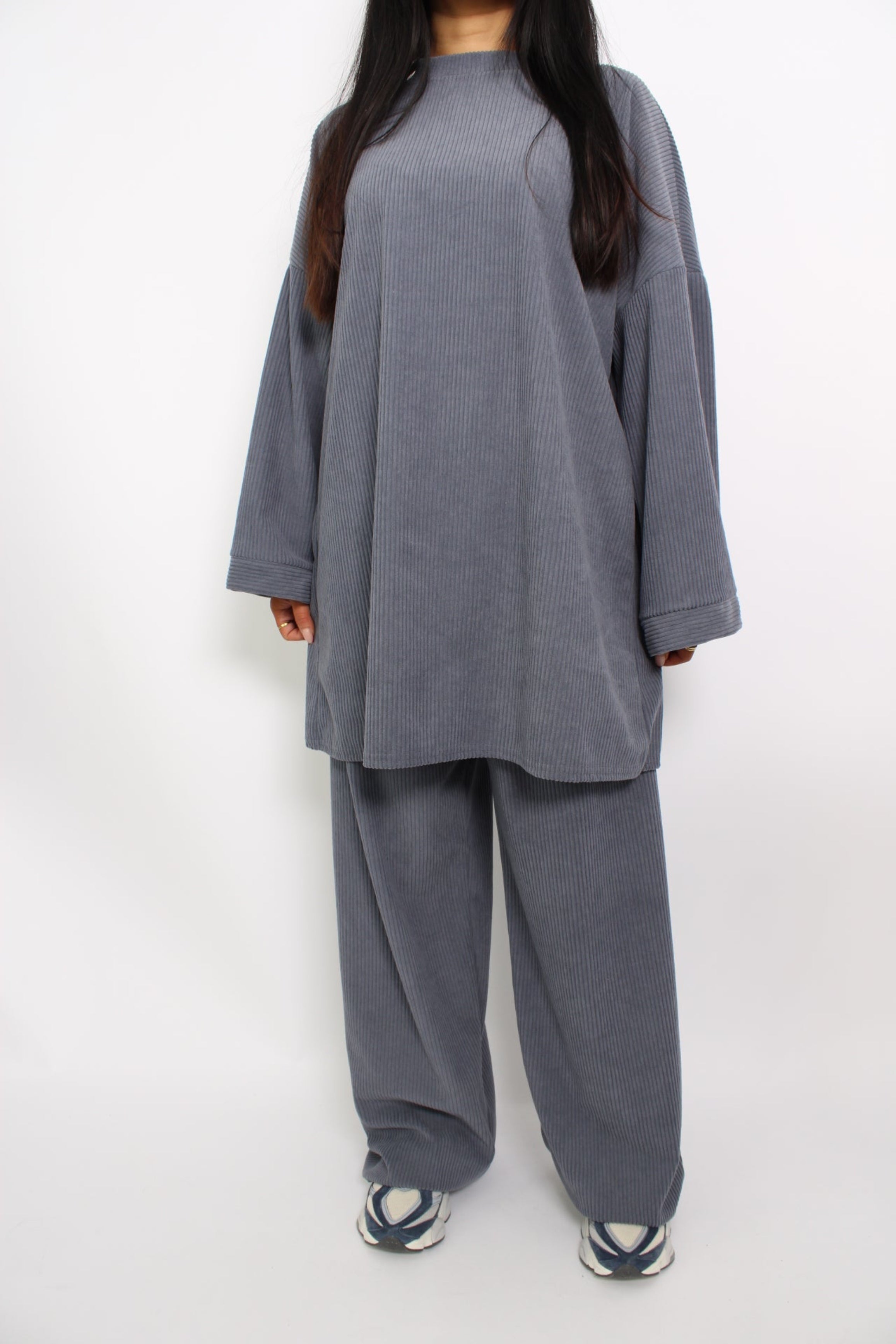 Een hijabproof tweedelige set van corduroy, bestaande uit een lange, losse top met lange mouwen en een bijpassende broek. De stof is comfortabel en ademend, met een tijdloze, elegante uitstraling