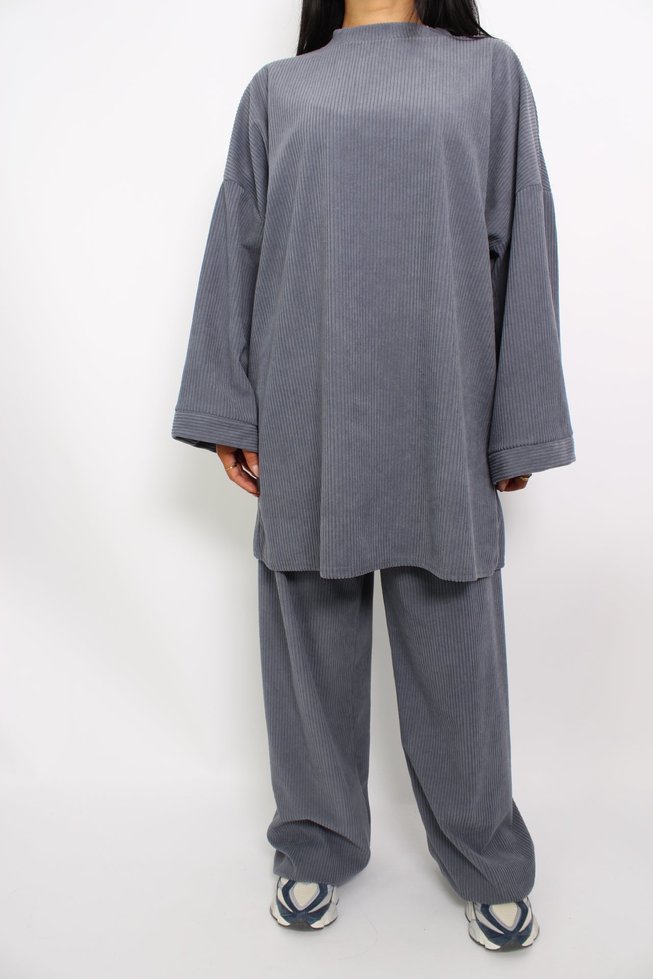 Een hijabproof tweedelige set van corduroy, bestaande uit een lange, losse top met lange mouwen en een bijpassende broek. De stof is comfortabel en ademend, met een tijdloze, elegante uitstraling