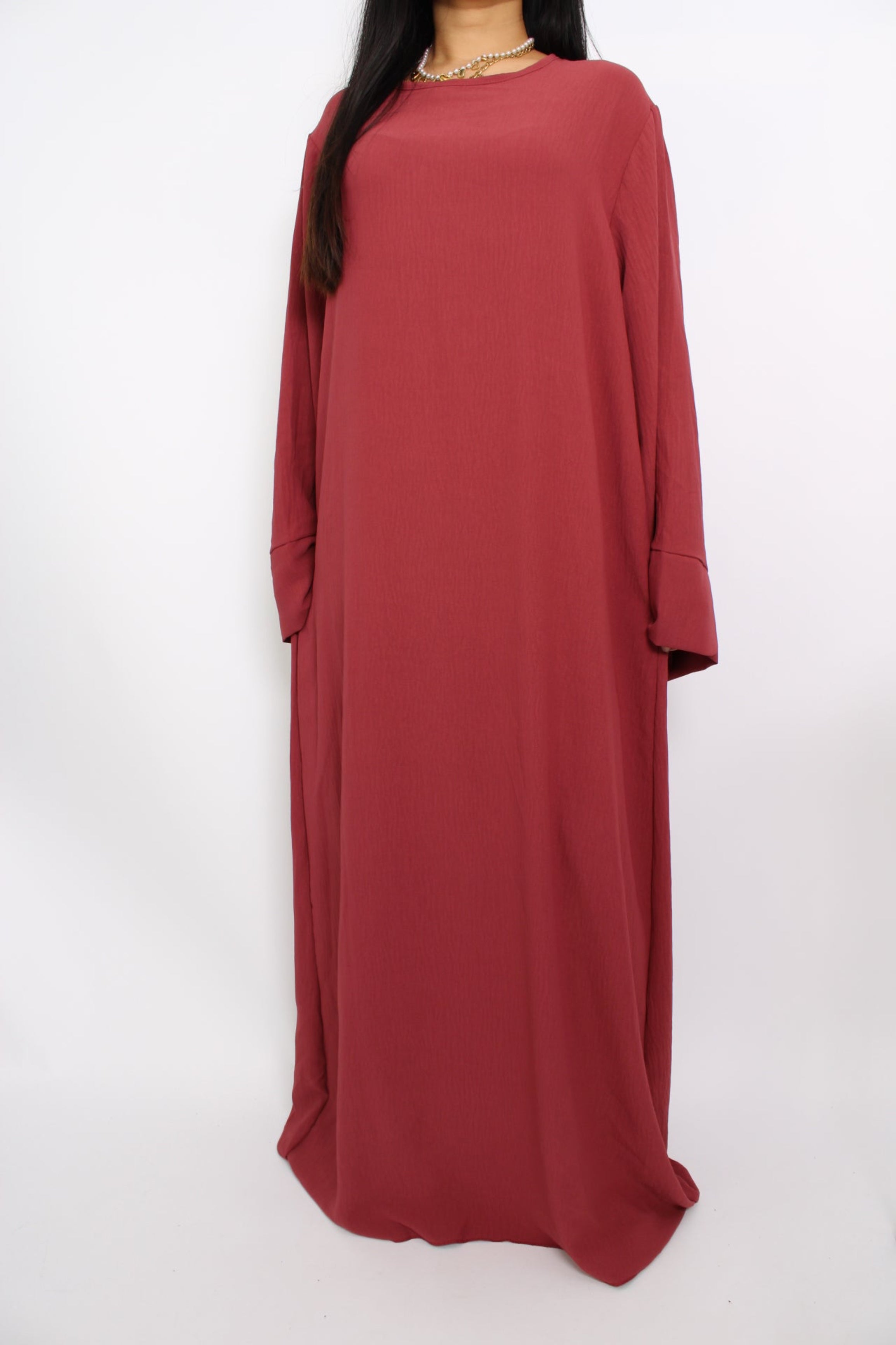 Een hijabproof jurk met lange mouwen, hoge halslijn en een losse pasvorm in ademende, niet-doorzichtige stof.