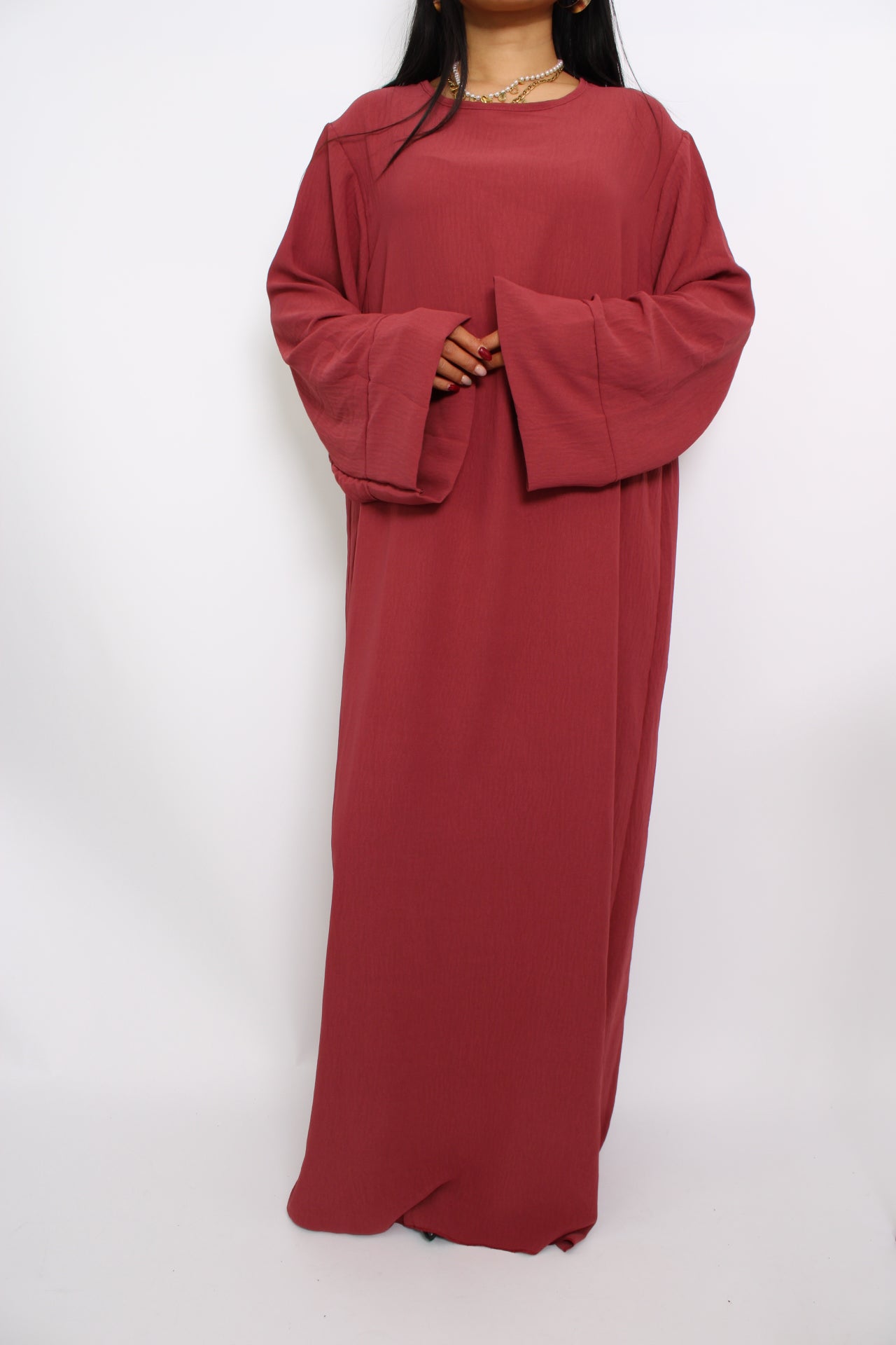 Een hijabproof jurk met lange mouwen, hoge halslijn en een losse pasvorm in ademende, niet-doorzichtige stof.