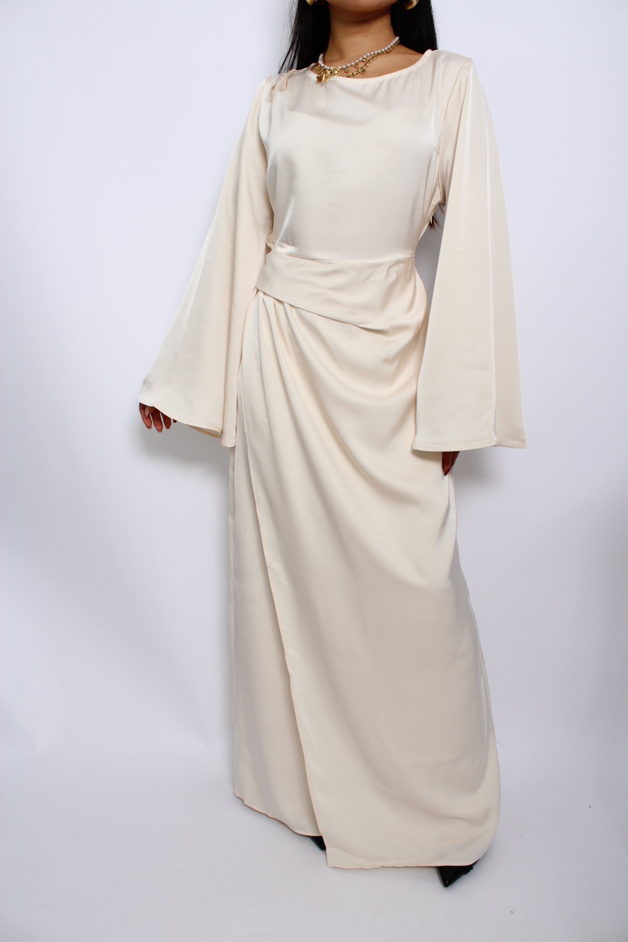 Een modest satijnen jurk met een vloeiende, elegante pasvorm, lange mouwen en een hoge halslijn. Gemaakt van glanzende, ademende stof voor een verfijnde uitstraling.