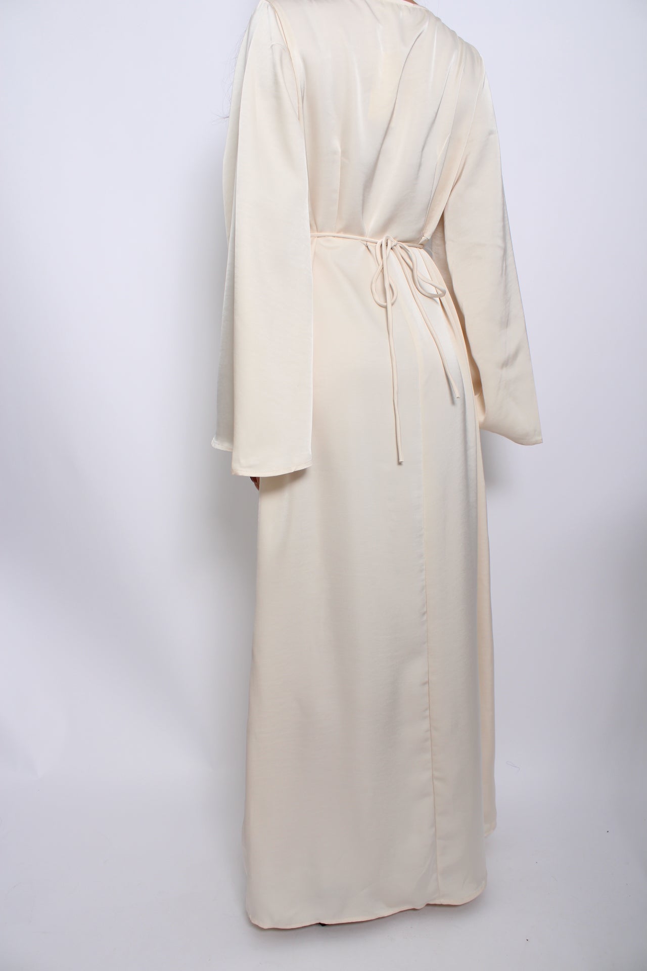 Een modest satijnen jurk met een vloeiende, elegante pasvorm, lange mouwen en een hoge halslijn. Gemaakt van glanzende, ademende stof voor een verfijnde uitstraling.