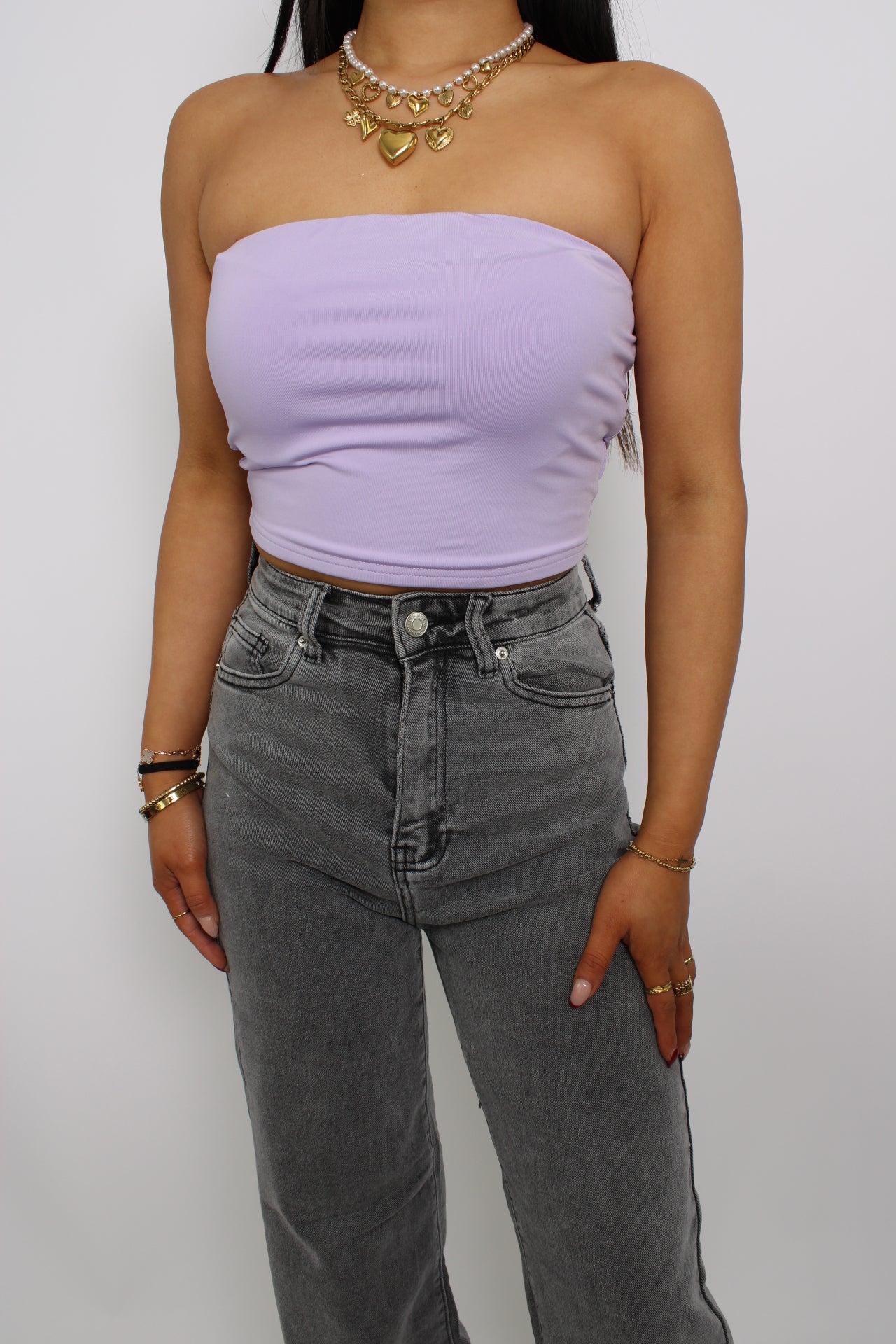Een strapless tube top, gemaakt van elastische stof voor een comfortabele, nauwsluitende pasvorm. Het ontwerp heeft geen bandjes en valt net boven de taille voor een trendy en casual look."