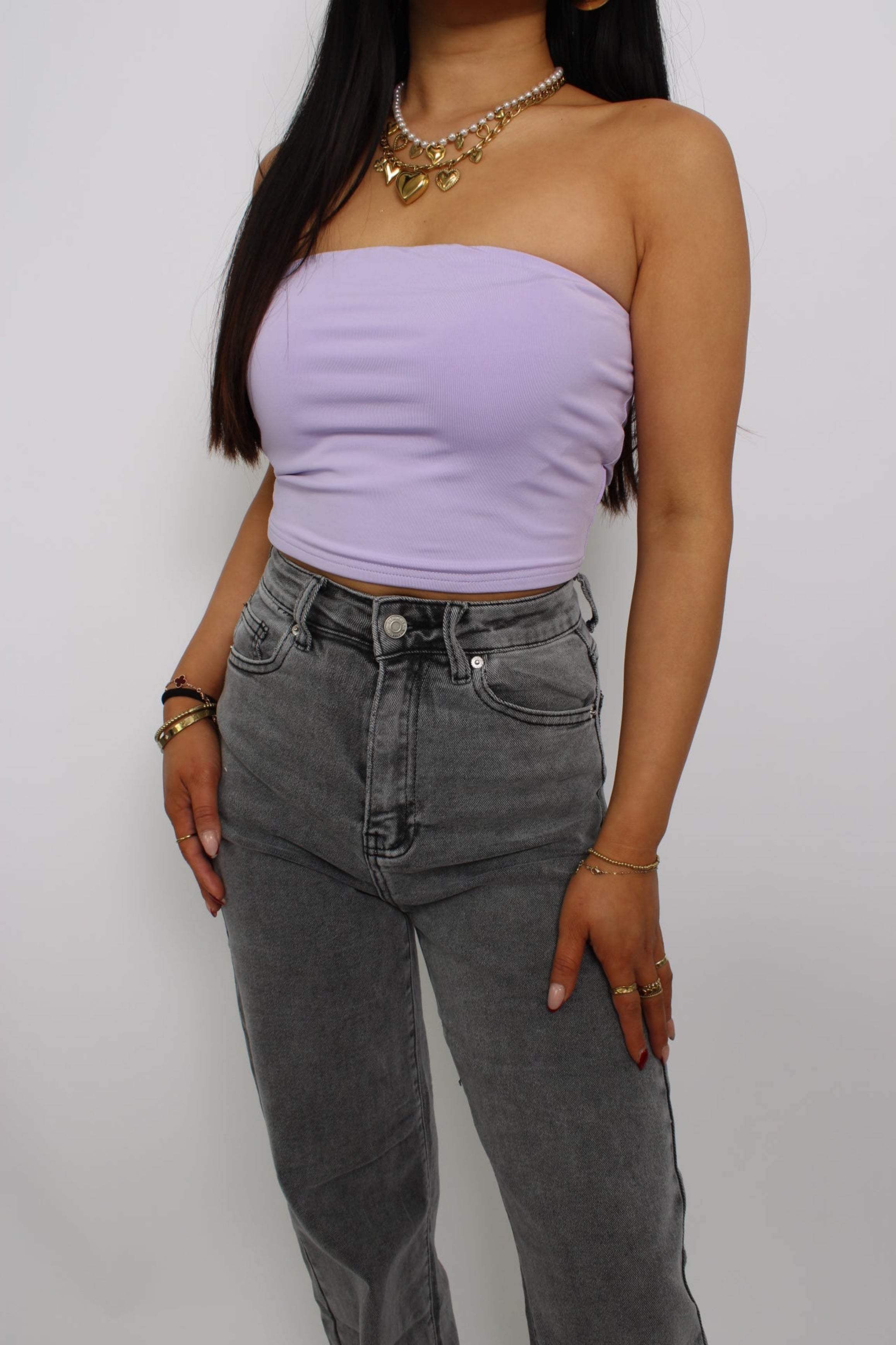 Een strapless tube top, gemaakt van elastische stof voor een comfortabele, nauwsluitende pasvorm. Het ontwerp heeft geen bandjes en valt net boven de taille voor een trendy en casual look.