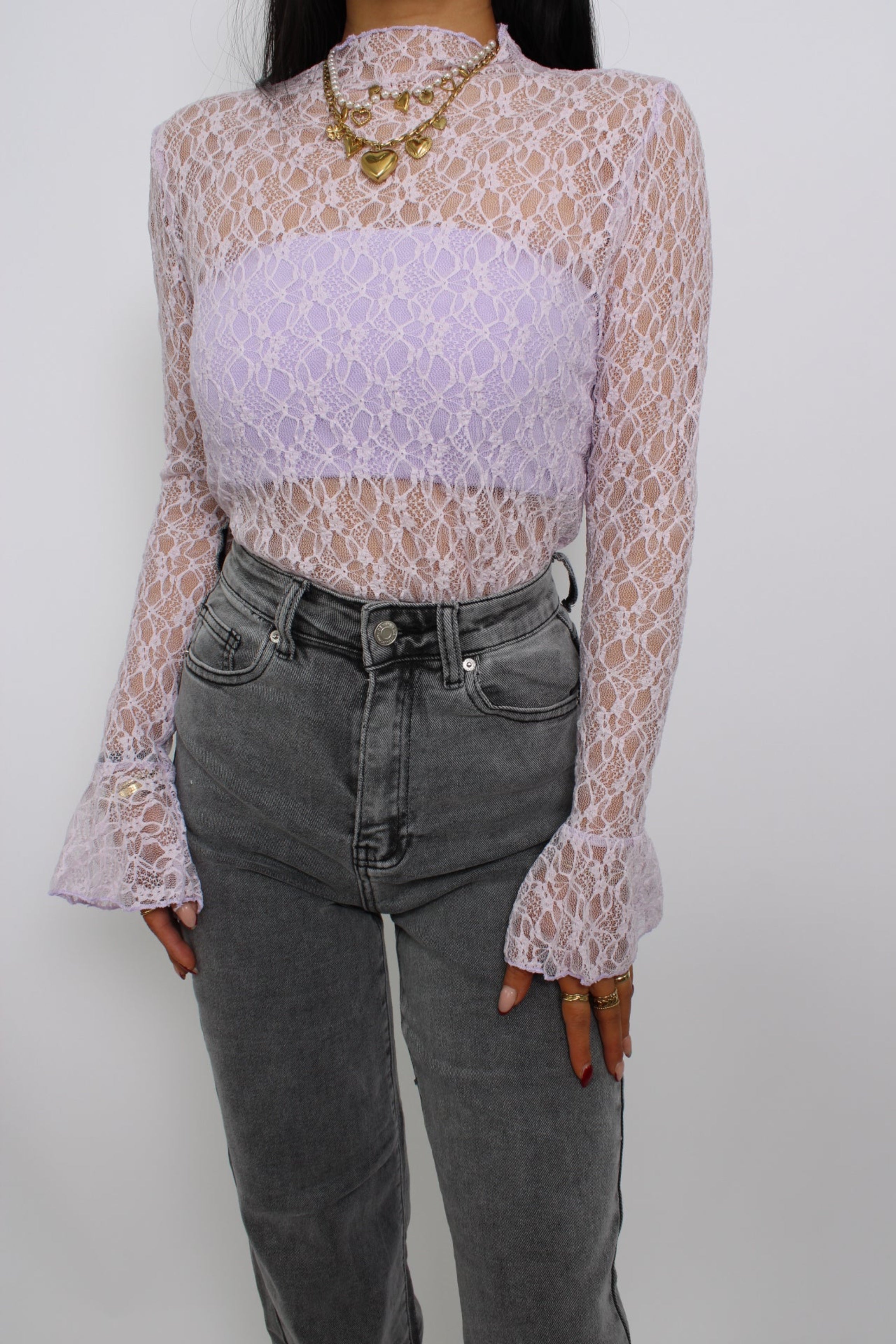 Een elegante kanten top met flare mouwen, een losse pasvorm en een verfijnde uitstraling. De top heeft een ronde halslijn en een delicate, doorzichtige stof voor een vrouwelijke look.